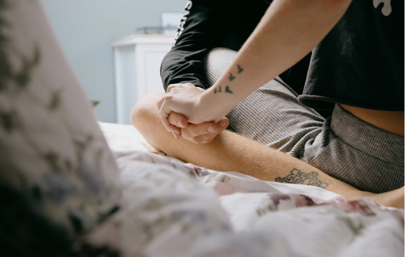 A couple holding hands on a bed