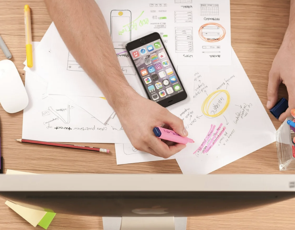 A photo of someone working with scattered pages on a desk