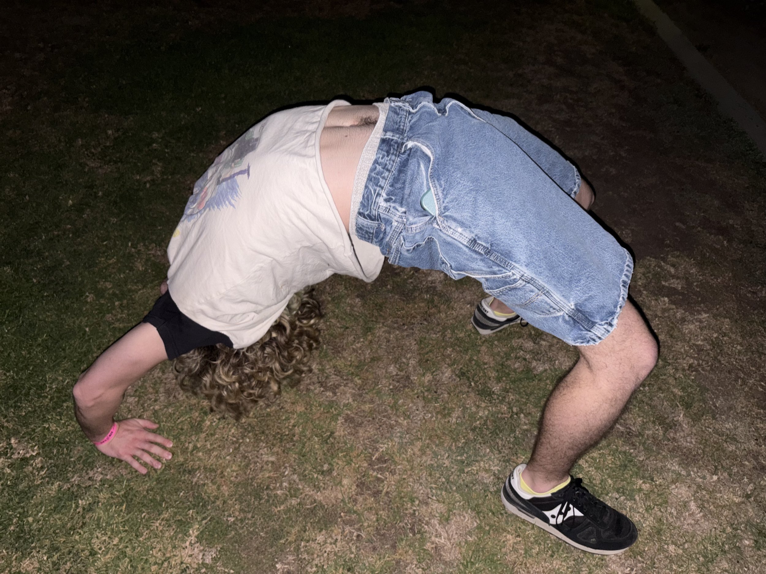a person doing a backbend on grass