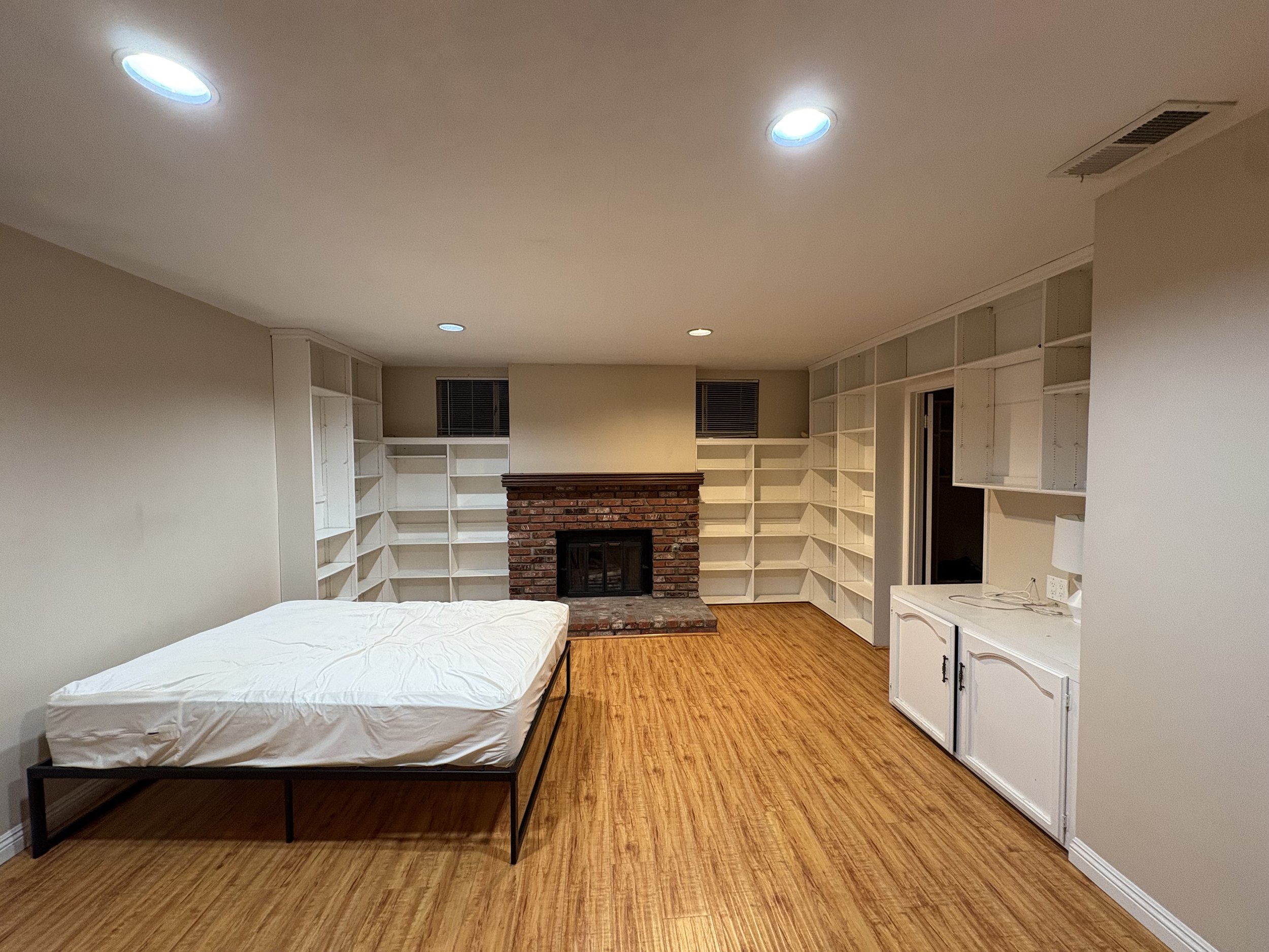 a mattress in an empty room with a fire place