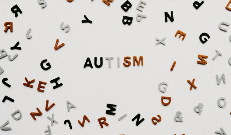 alphabet letters scattered around, spelling "Autism"