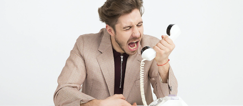 a man in a suit screaming into a phone