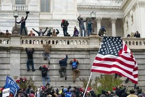 “Far-right” rioters scale a wall during the insurrection at the U.S. Capitol on Jan. 6, 2021.