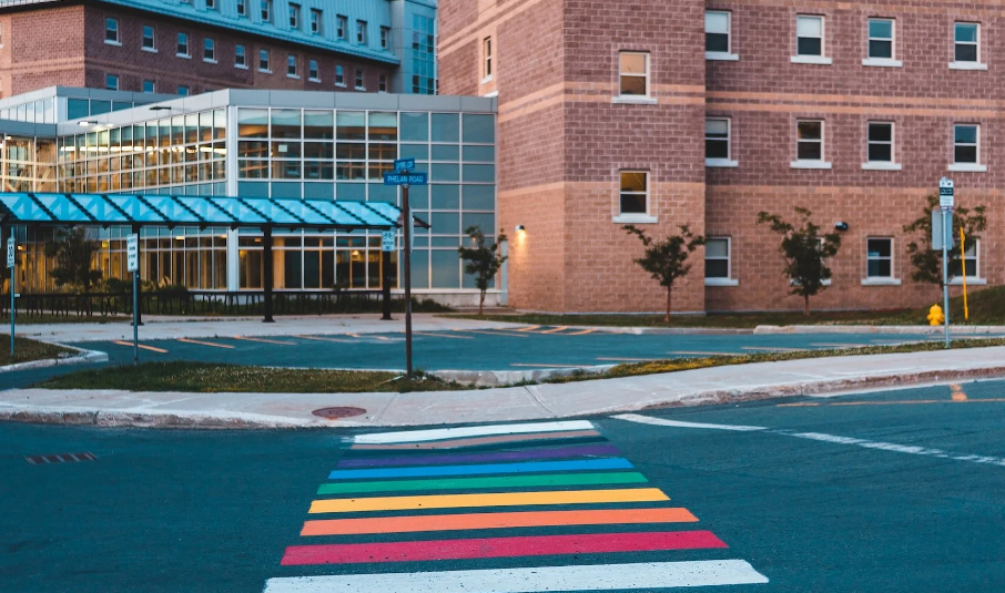 a building with a rainbow crosswalk leading up to it