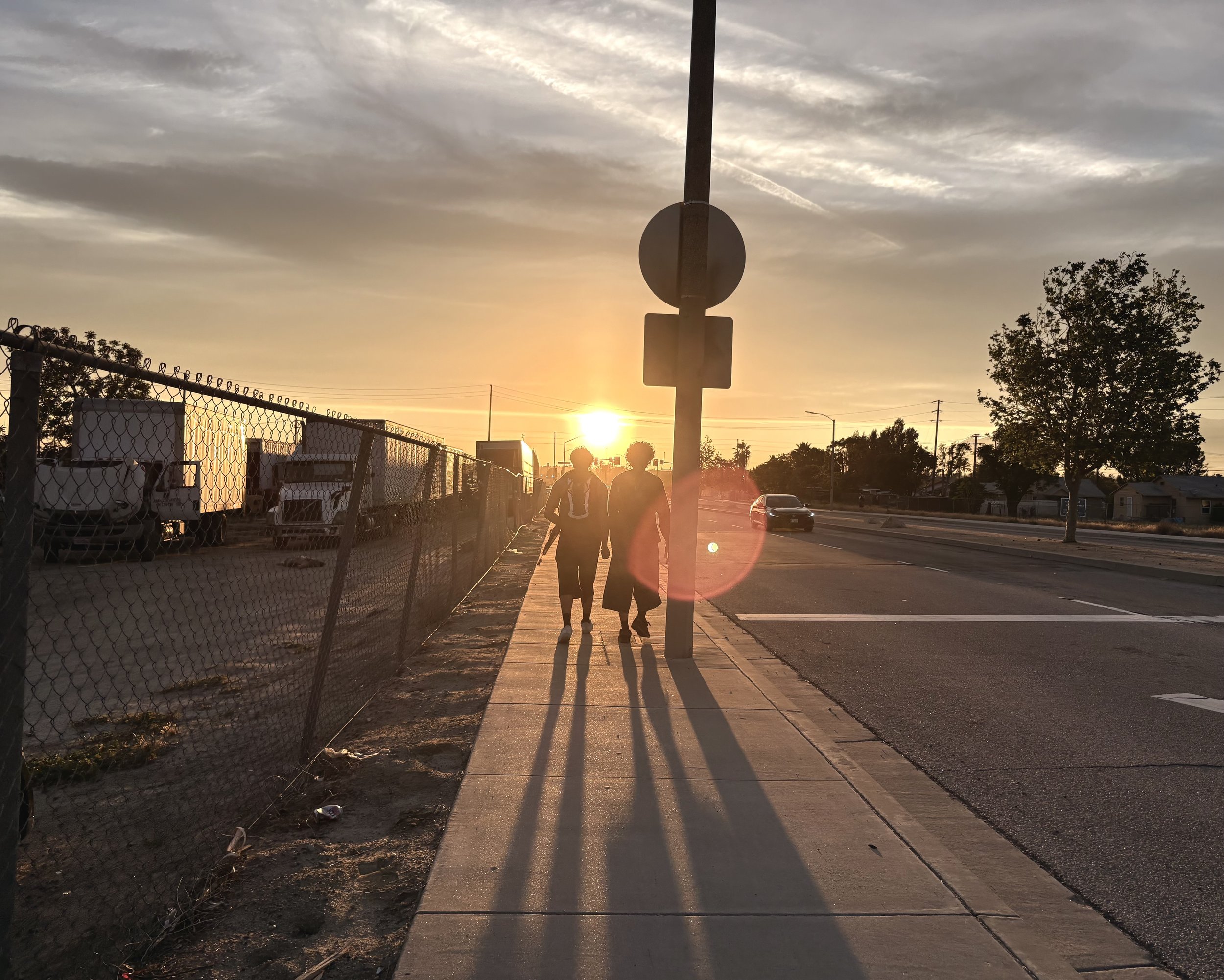 two people walking into a sunset