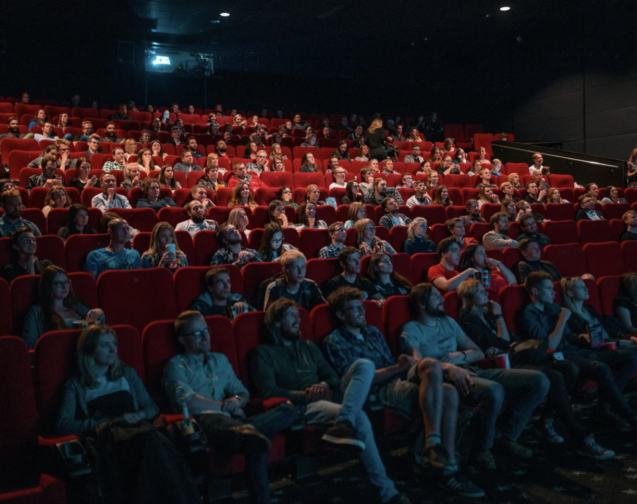 Image of a movie theater with an audience watching a film.
