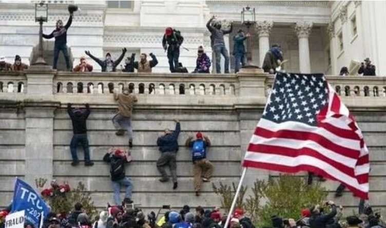January 6th Insurrectionists scaling the wall of the Capitol during January 6th
