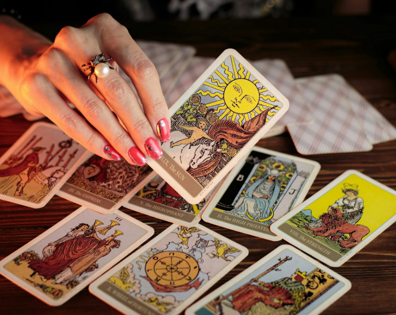 a woman holding up a tarot card