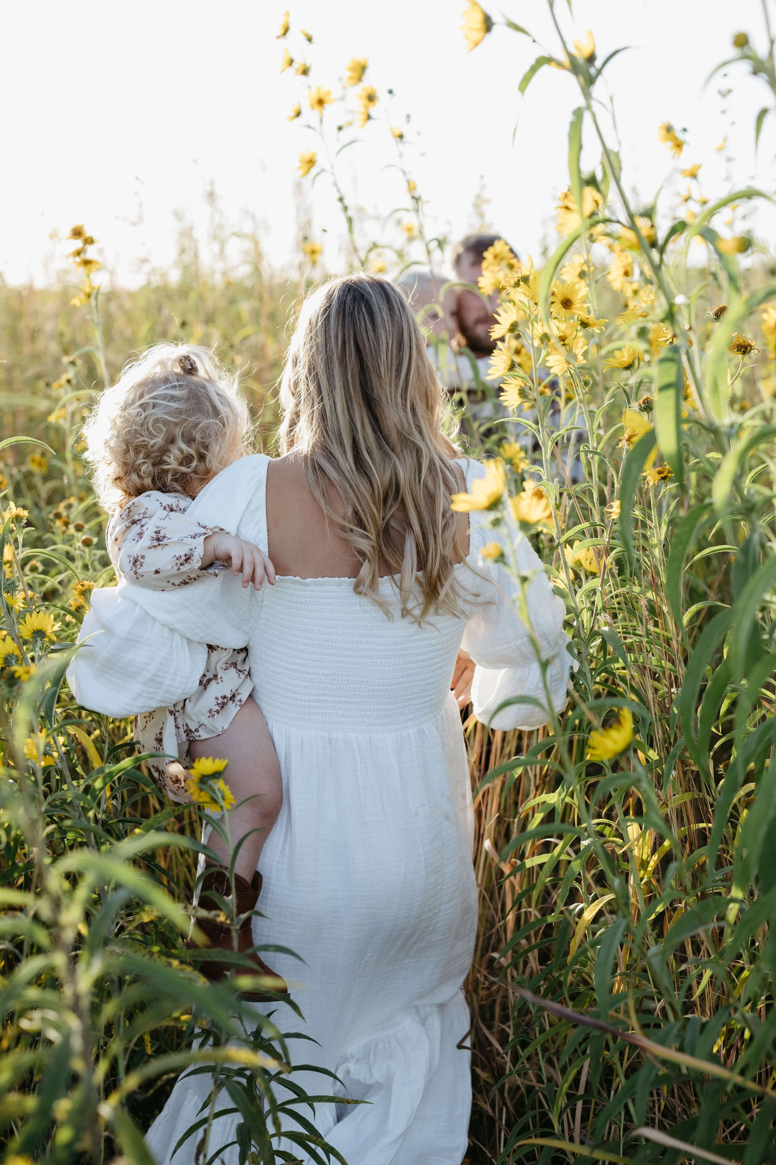 Family in a flower field during family photo session at sunset with family photographer Jenna Heckel Photography.