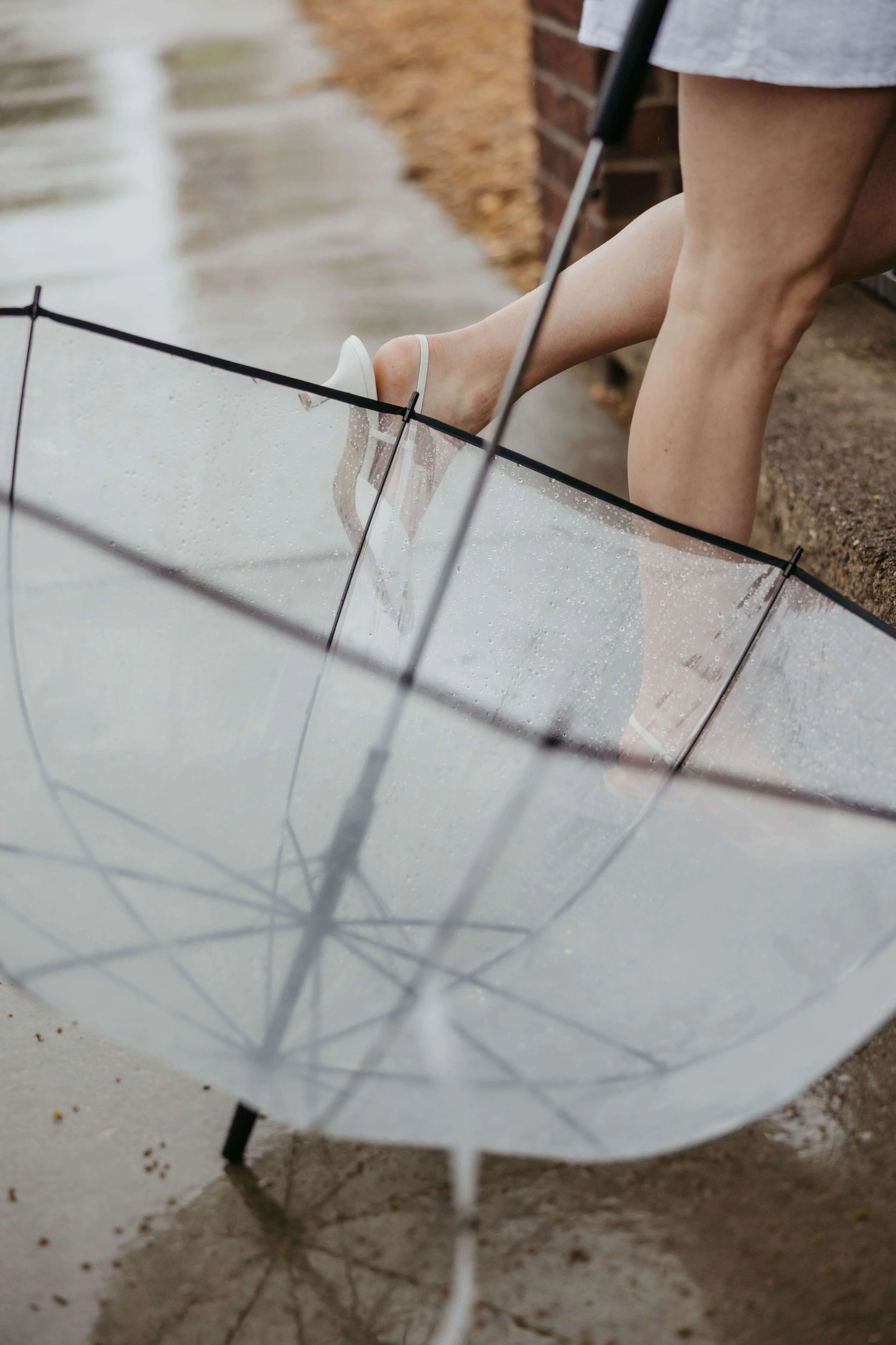 Couple caught in the rain during downtown Sioux Falls engagement session photographed by Jenna Heckel.