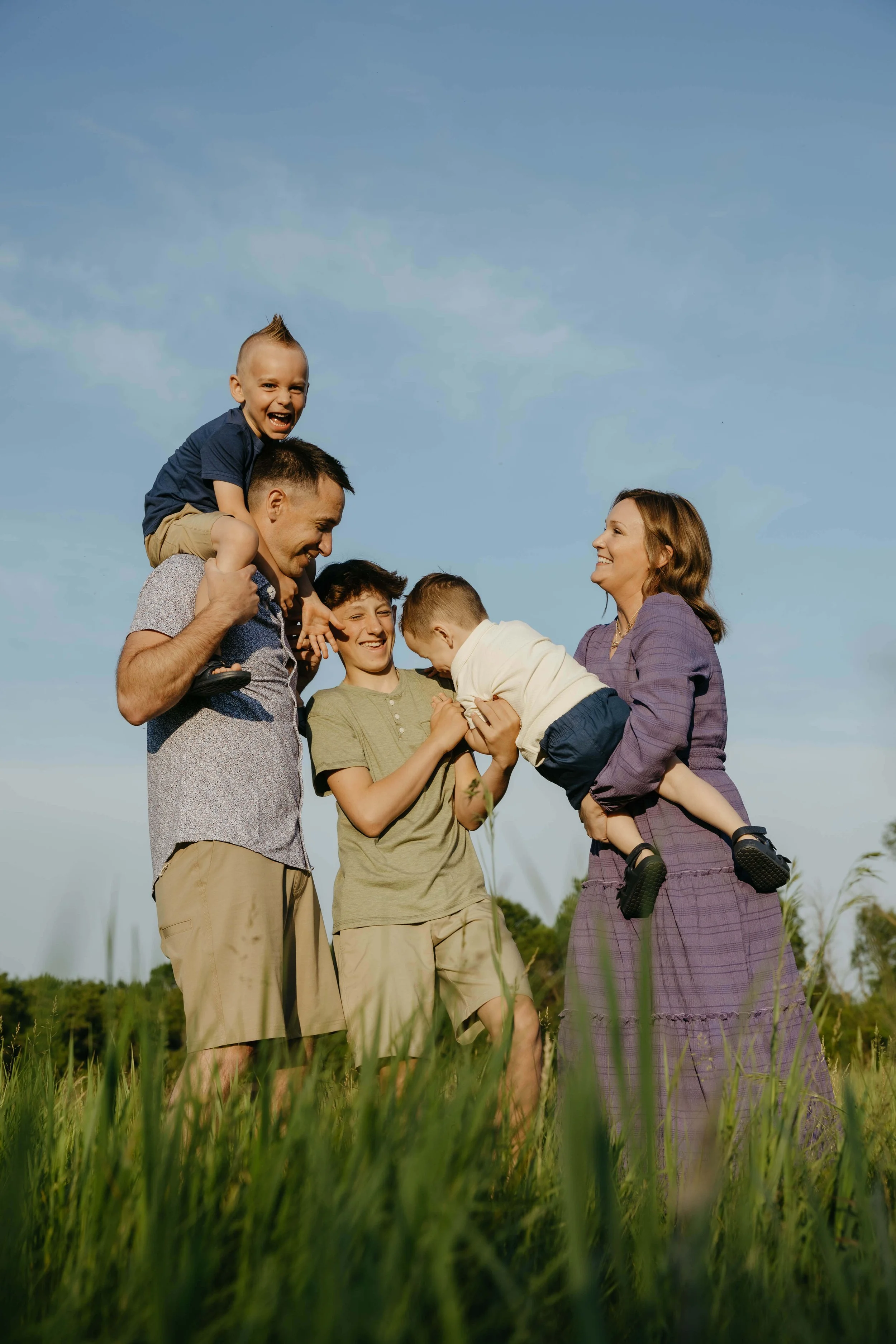 Family doing candid family portraits at sunset at Perry Nature Area near Sioux Falls, South Dakota. Photographed by Jenna Heckel Photography.