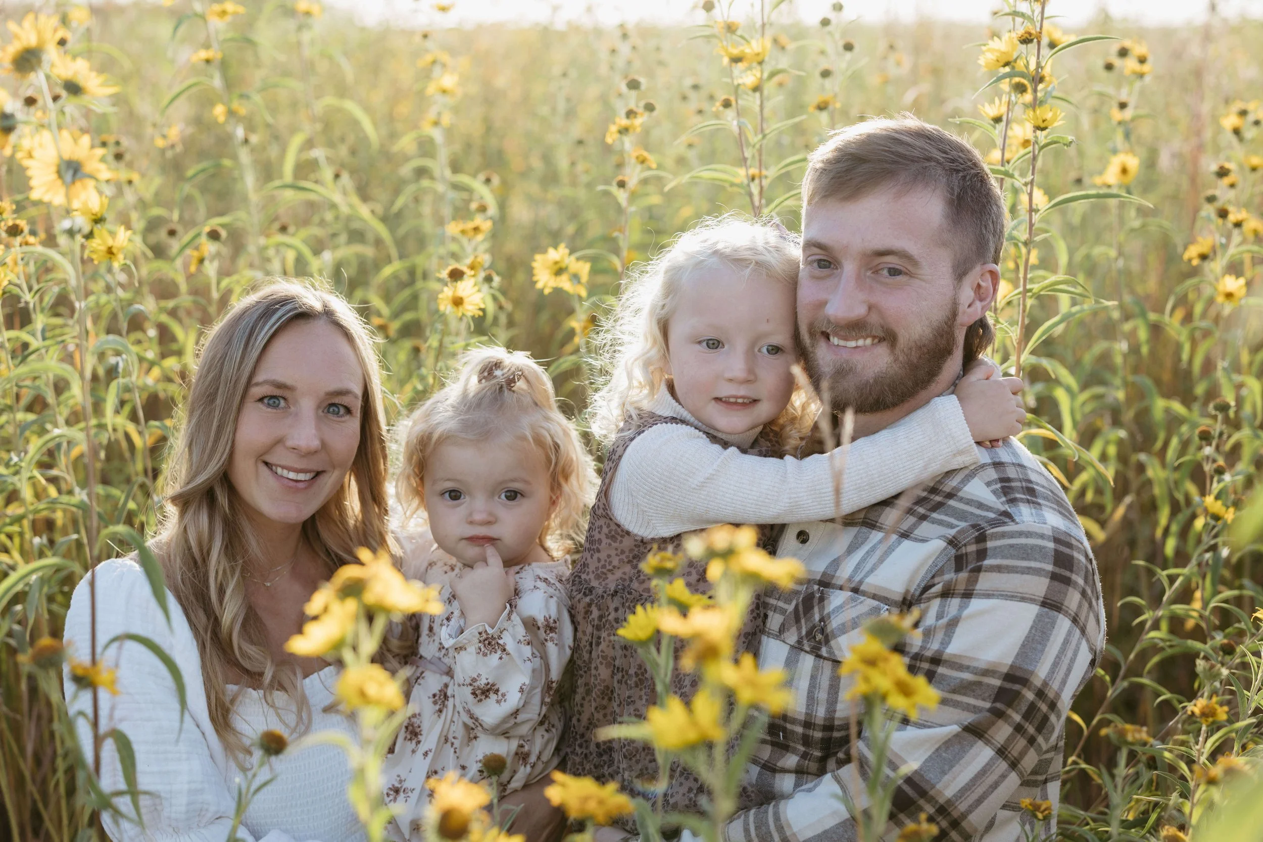 Family in a flower field during family photo session at sunset with family photographer Jenna Heckel Photography.