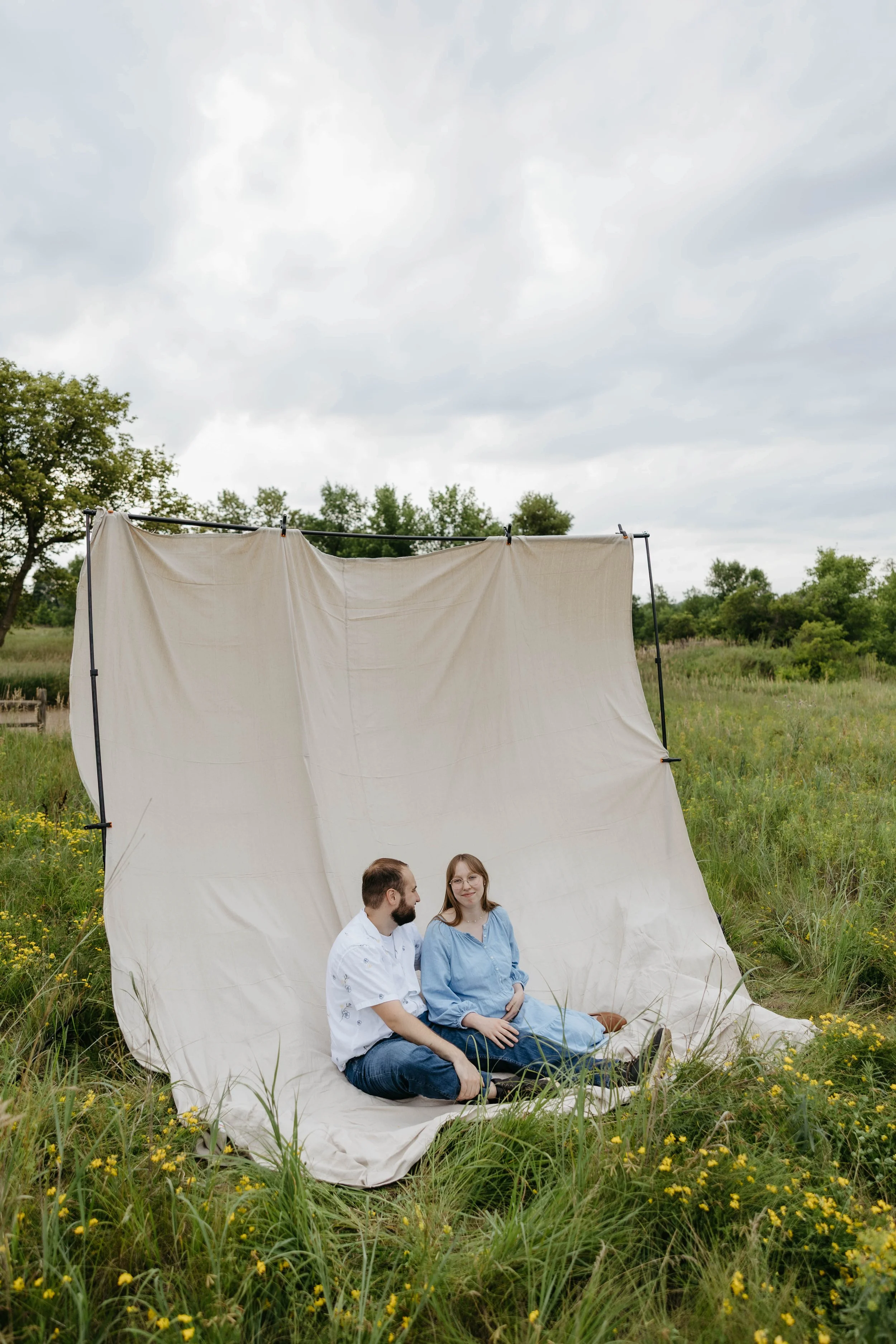 Couple doing maternity photos at sunset at Mary Jo Wegner near Sioux Falls, South Dakota. Photographed by Jenna Heckel Photography.