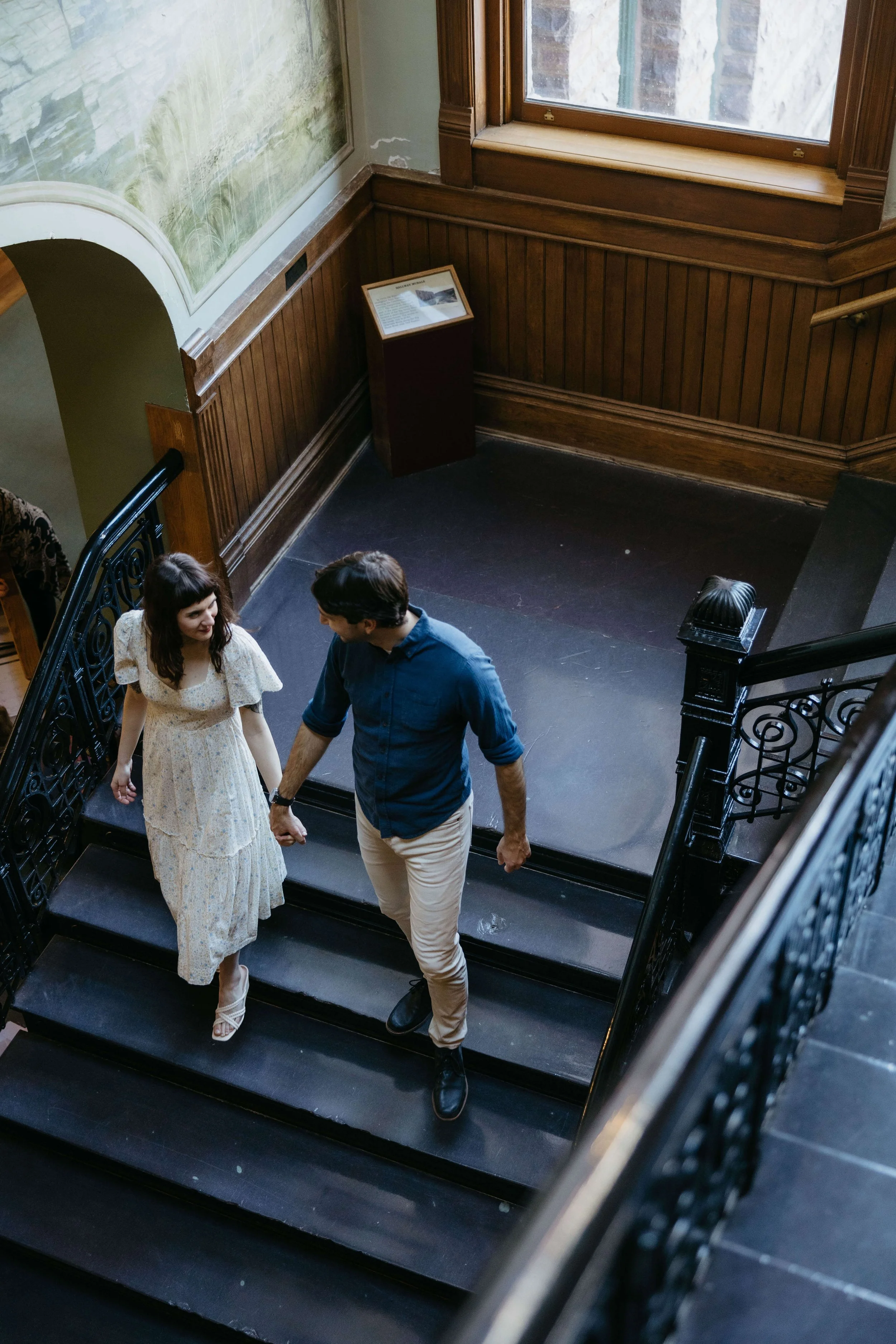 Engaged couple walking hand in hand at the Old Courthouse Museum in downtown Sioux Falls. Photographed by Jenna Heckel photography.