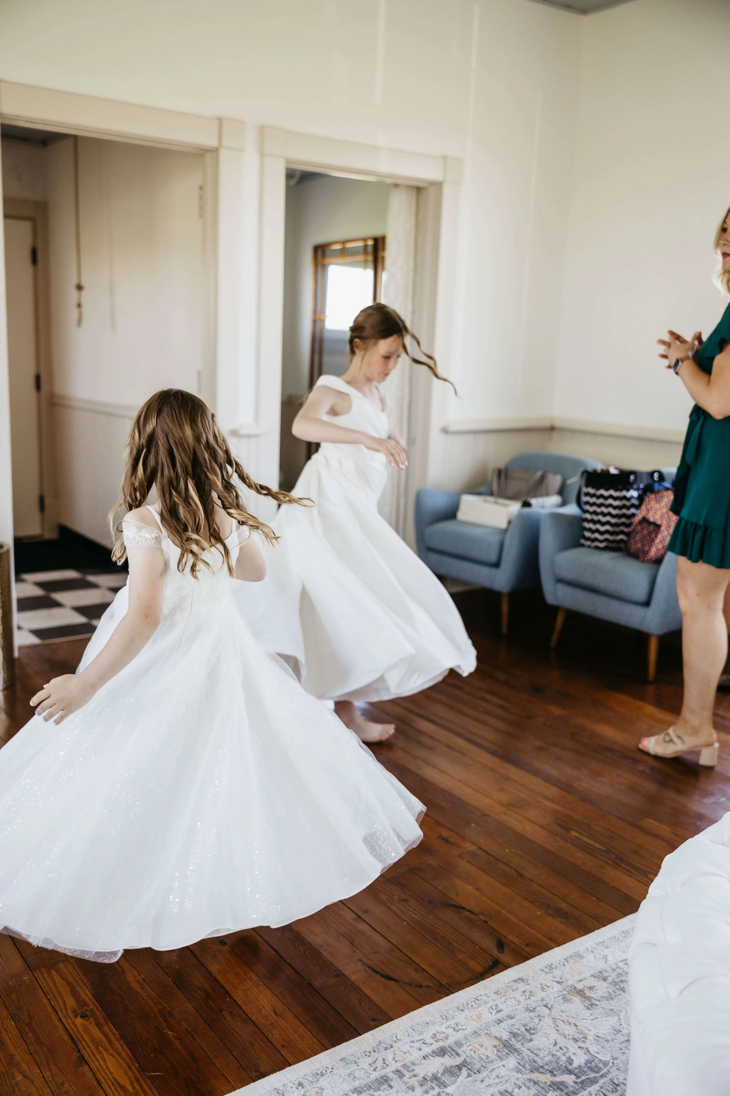 Flower girls at their parents wedding dancing together before the wedding