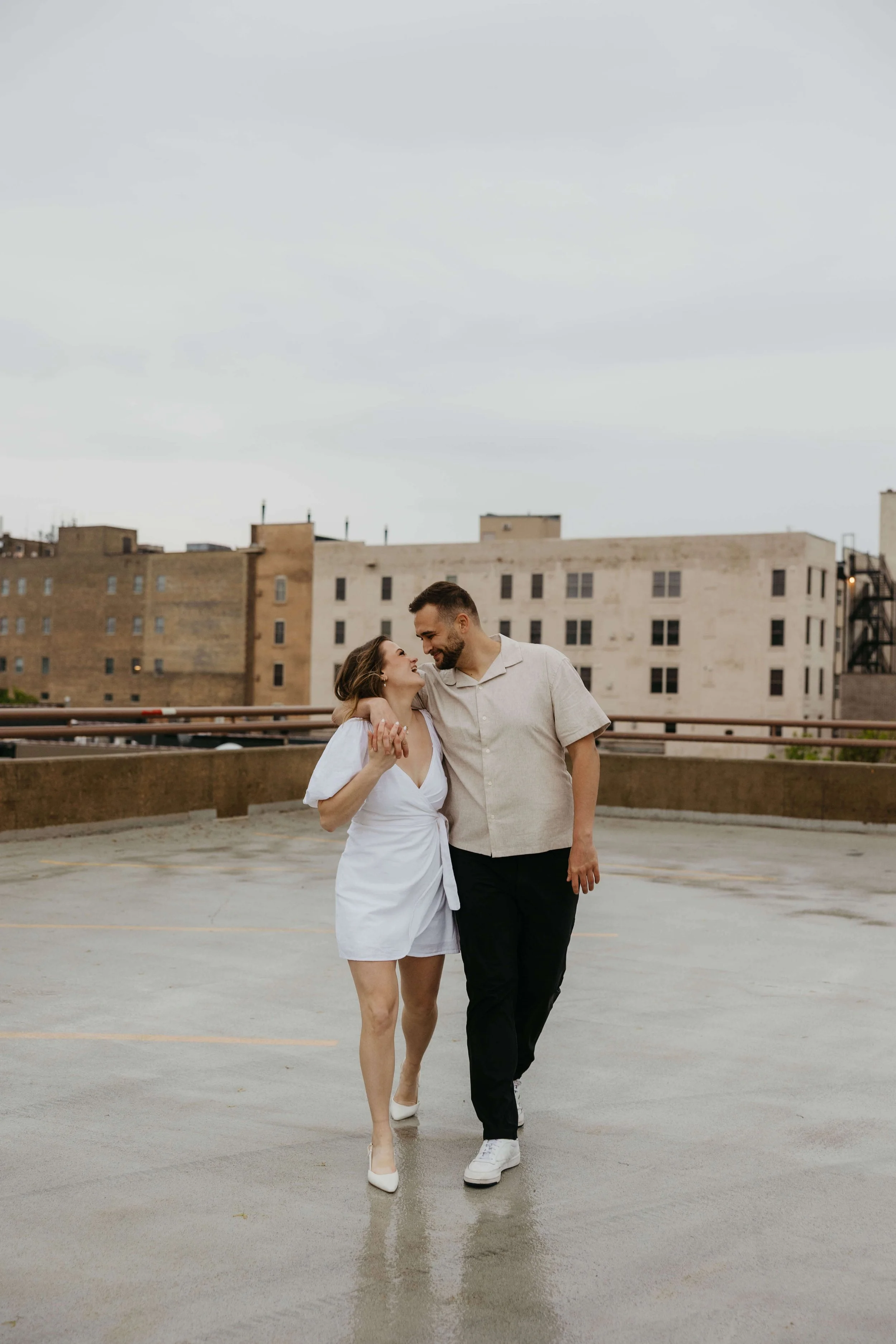 Couple caught in the rain during downtown Sioux Falls engagement session photographed by Jenna Heckel.