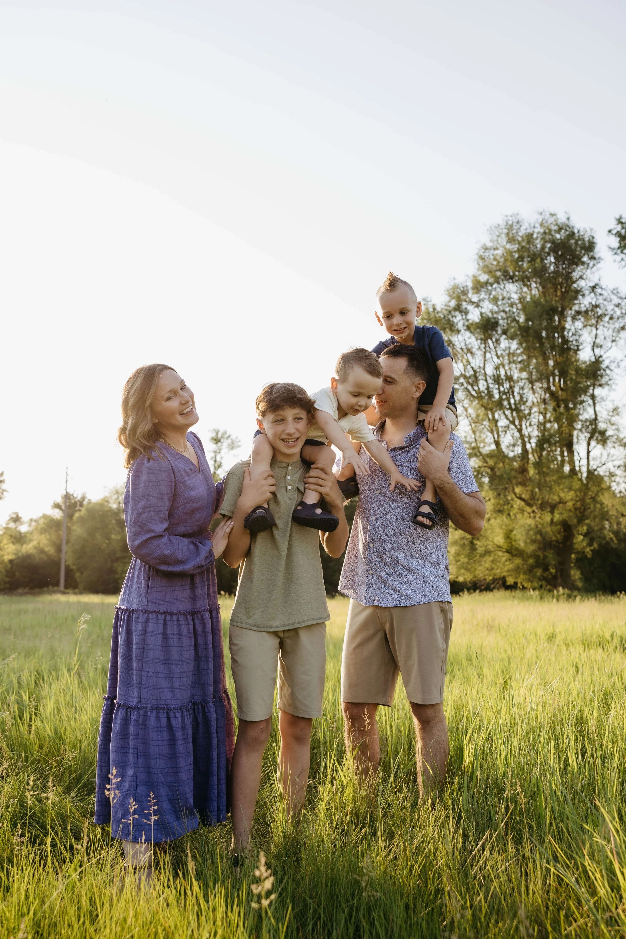 Family doing candid family portraits at sunset at Perry Nature Area near Sioux Falls, South Dakota. Photographed by Jenna Heckel Photography.