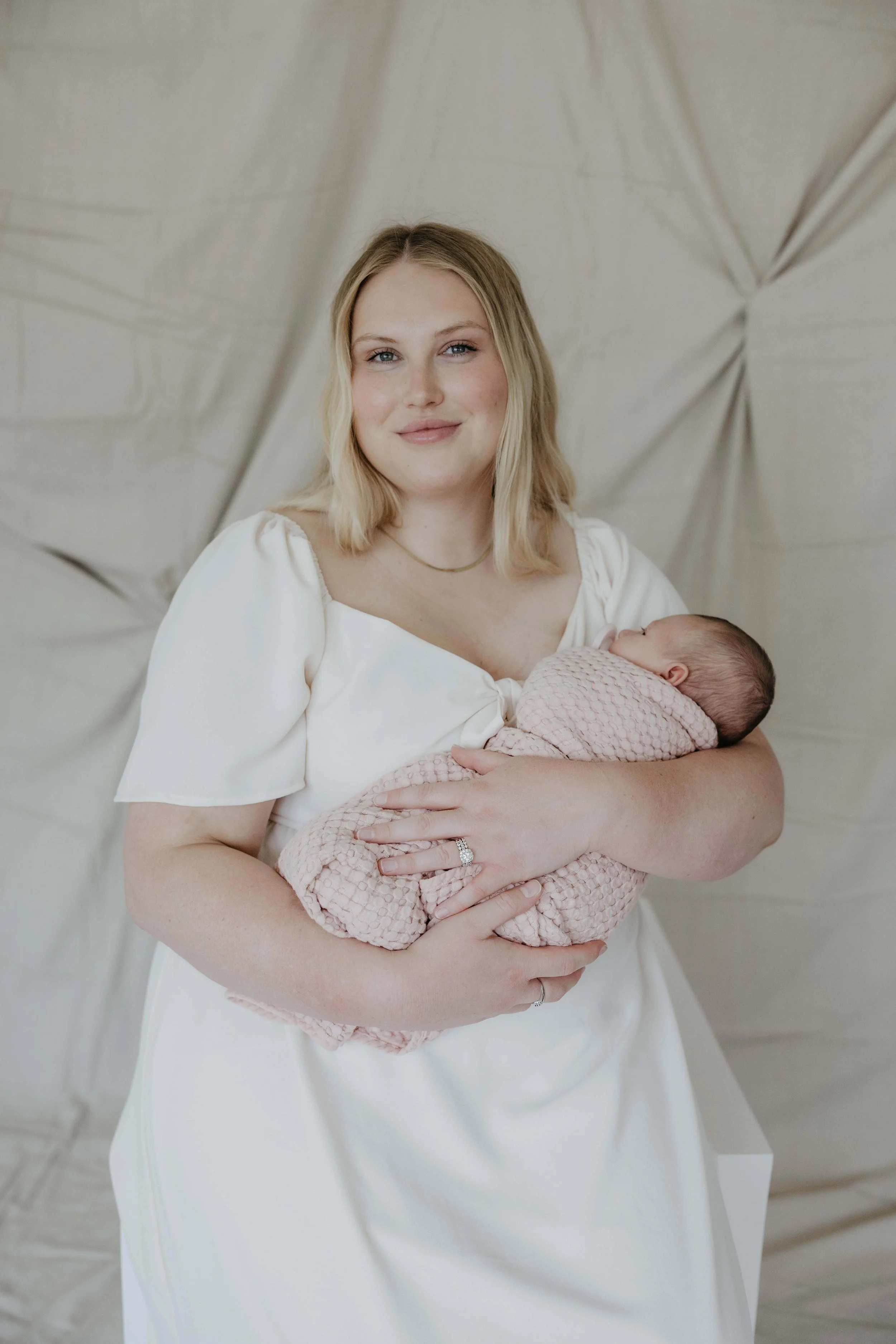 Mother during lifestyle newborn session at Jenna Heckel Photography's studio in Sioux Falls, South Dakota.