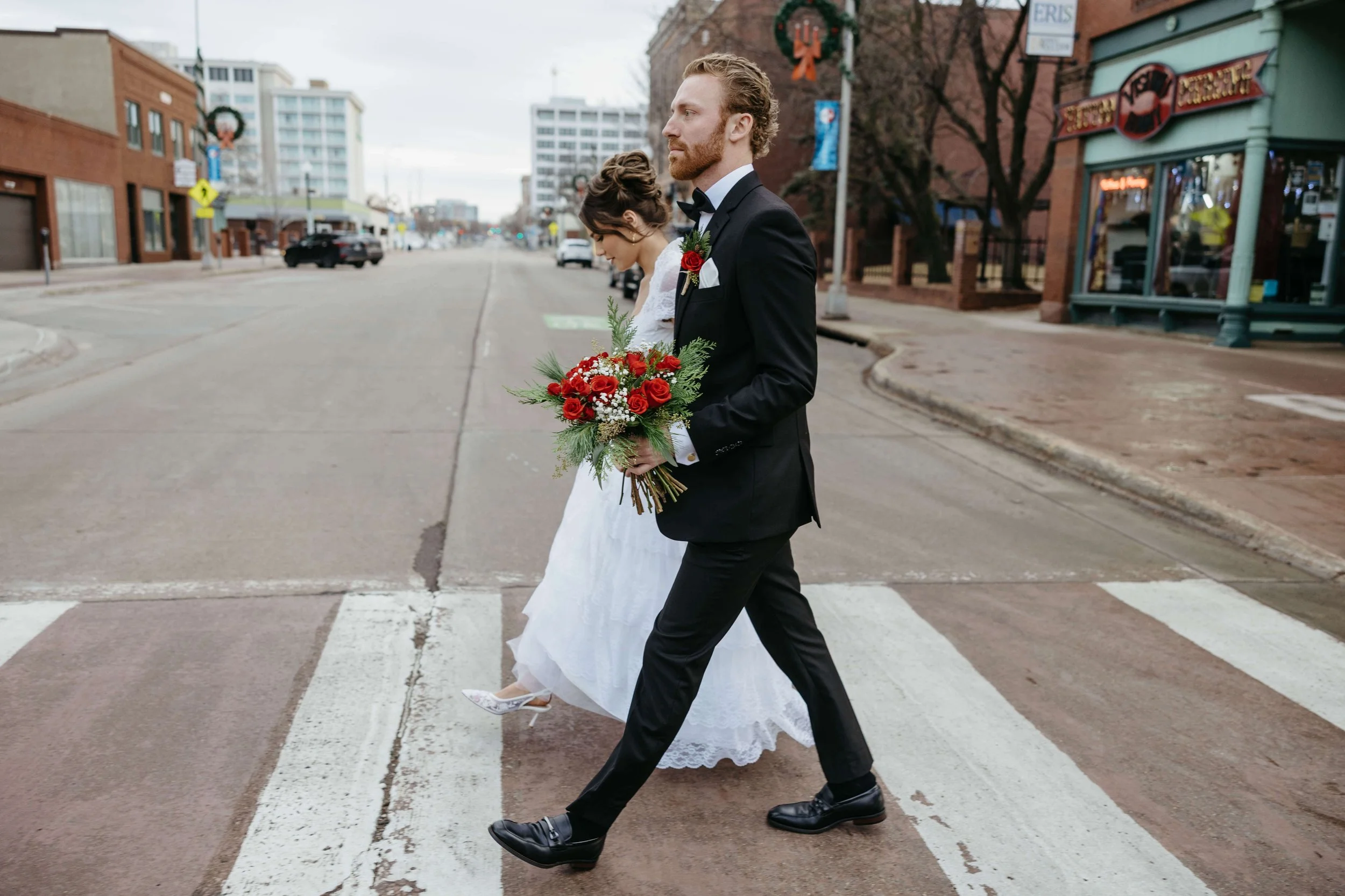 Bride and groom taking candid's during their micro wedding in downtown Sioux Falls outside the Icon with Jenna Heckel Photography a Sioux Falls Photographer.