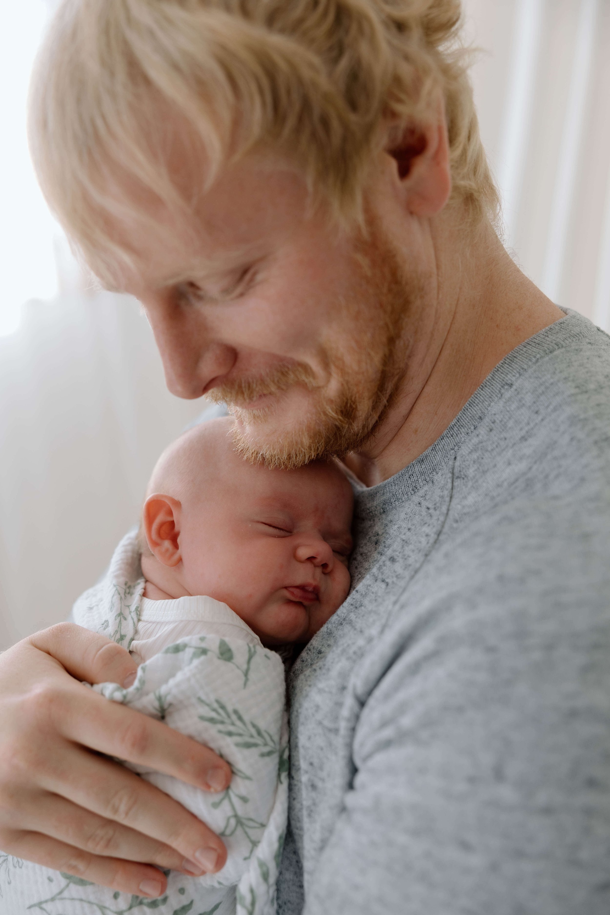 Father and baby during lifestyle newborn session at Jenna Heckel Photography's studio in Sioux Falls, South Dakota.