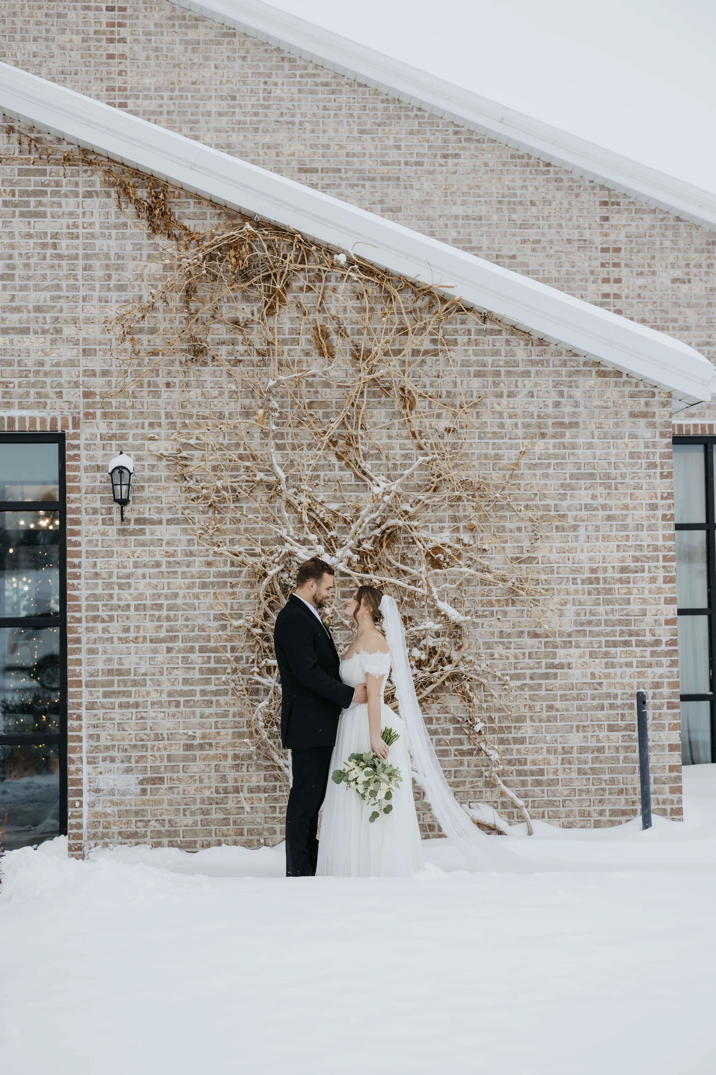 Couple on their wedding day doing couple portraits in the snow at The Atrium in Sioux Falls, South Dakota.