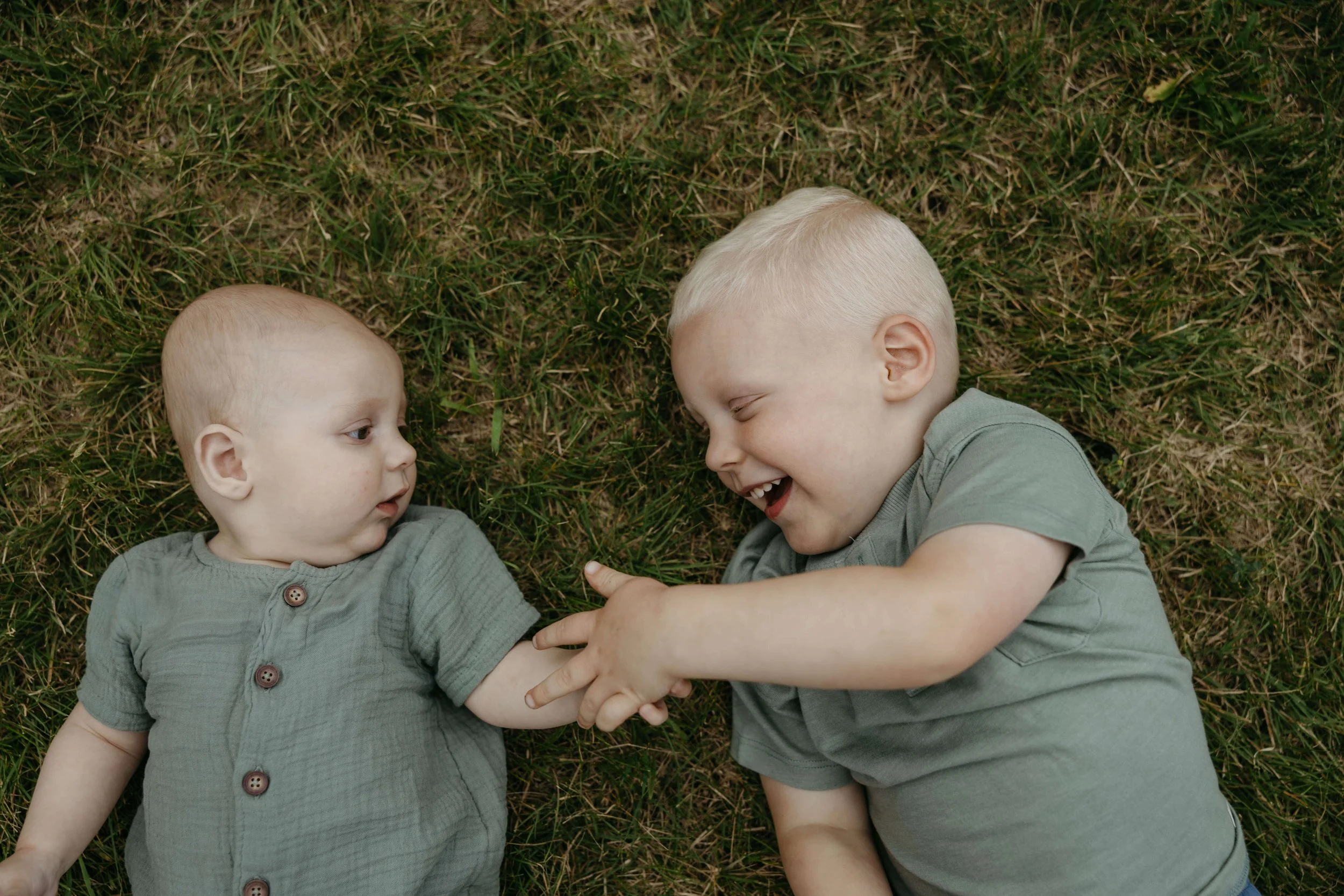 Toddler and baby brother playing during family pictures at Lake Alvin near Sioux Falls.