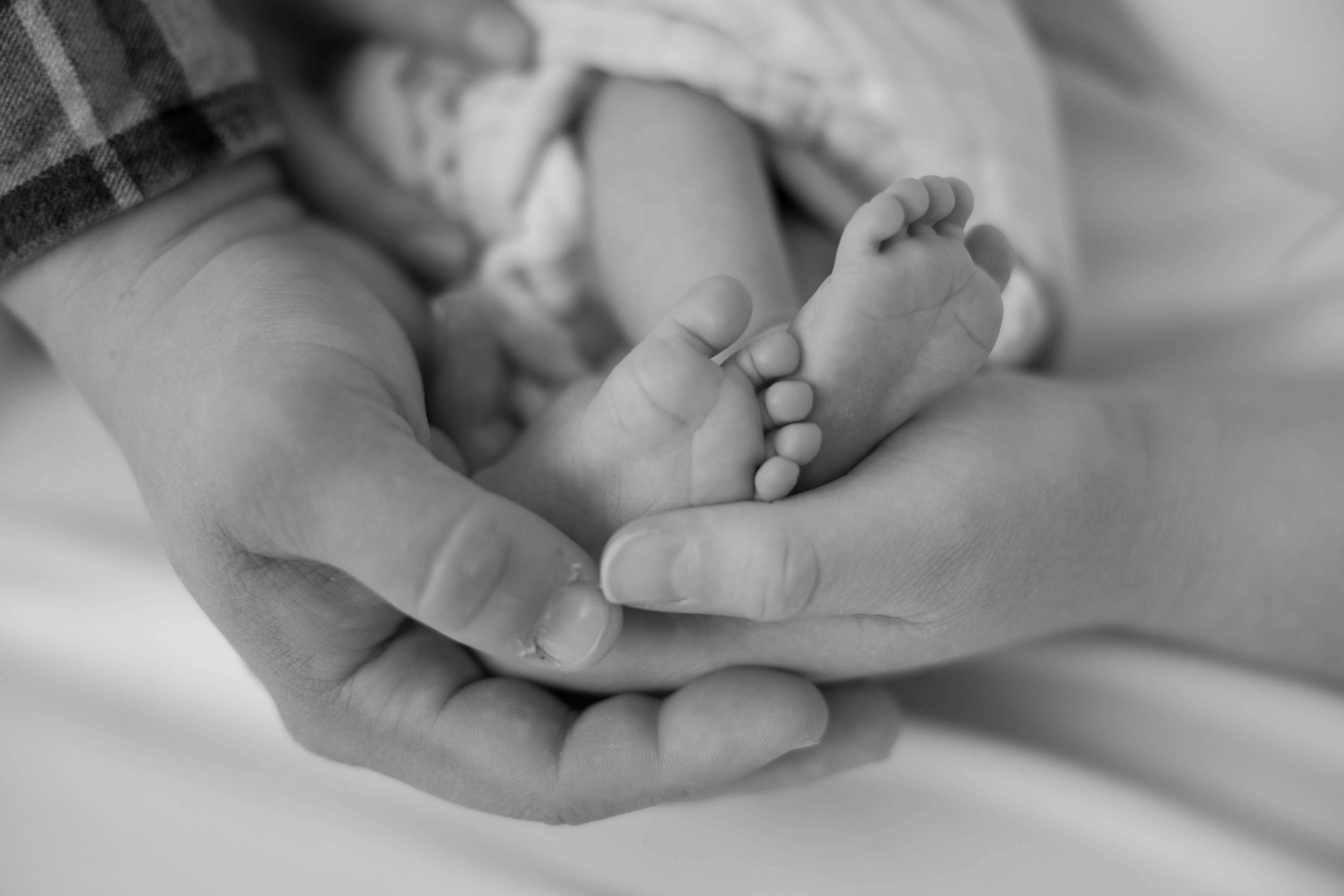 Family of three during lifestyle newborn session at Jenna Heckel Photography's studio in Sioux Falls, South Dakota.
