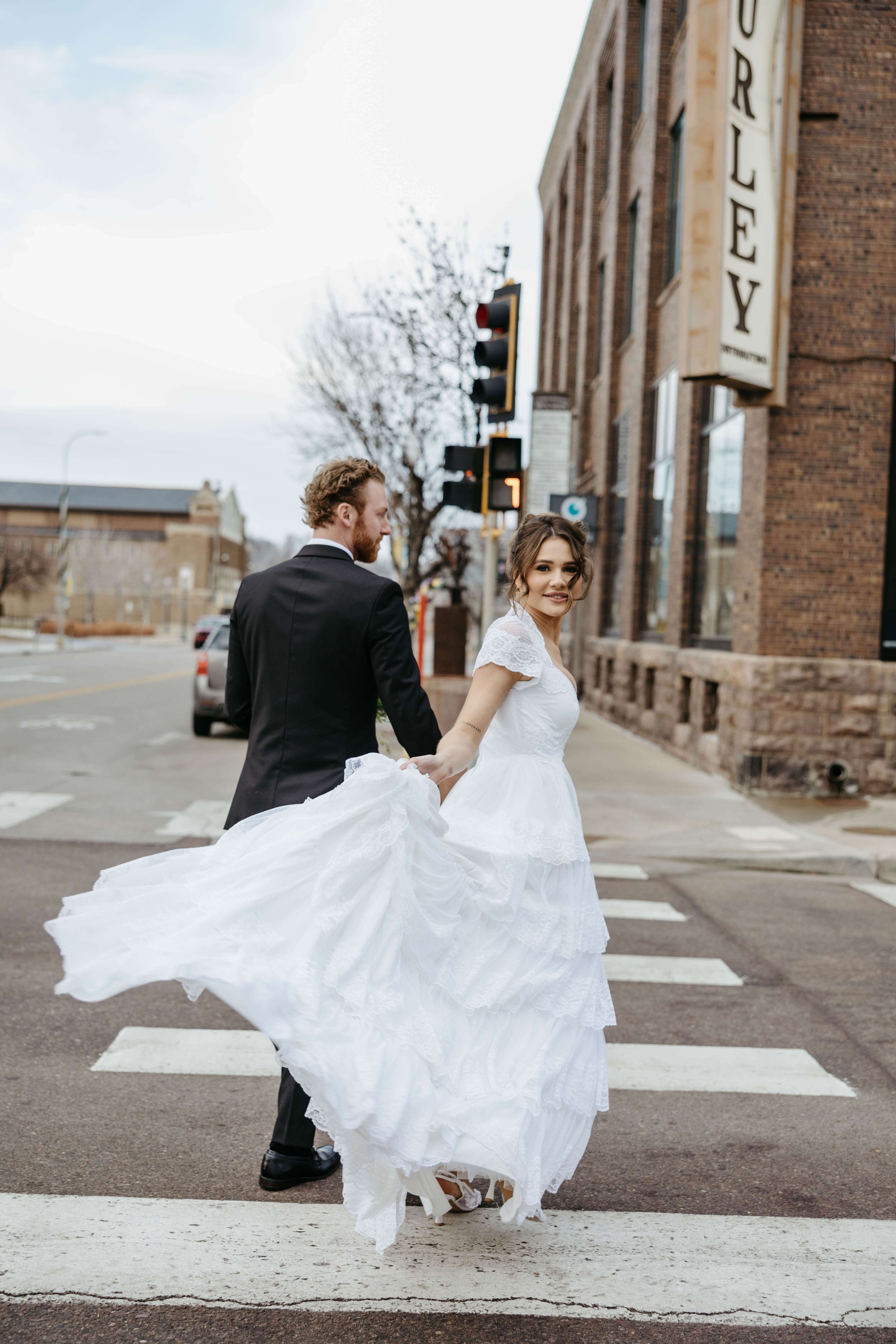 Bride and groom taking candid's during their micro wedding in downtown Sioux Falls outside the Icon with Jenna Heckel Photography a Sioux Falls Photographer.