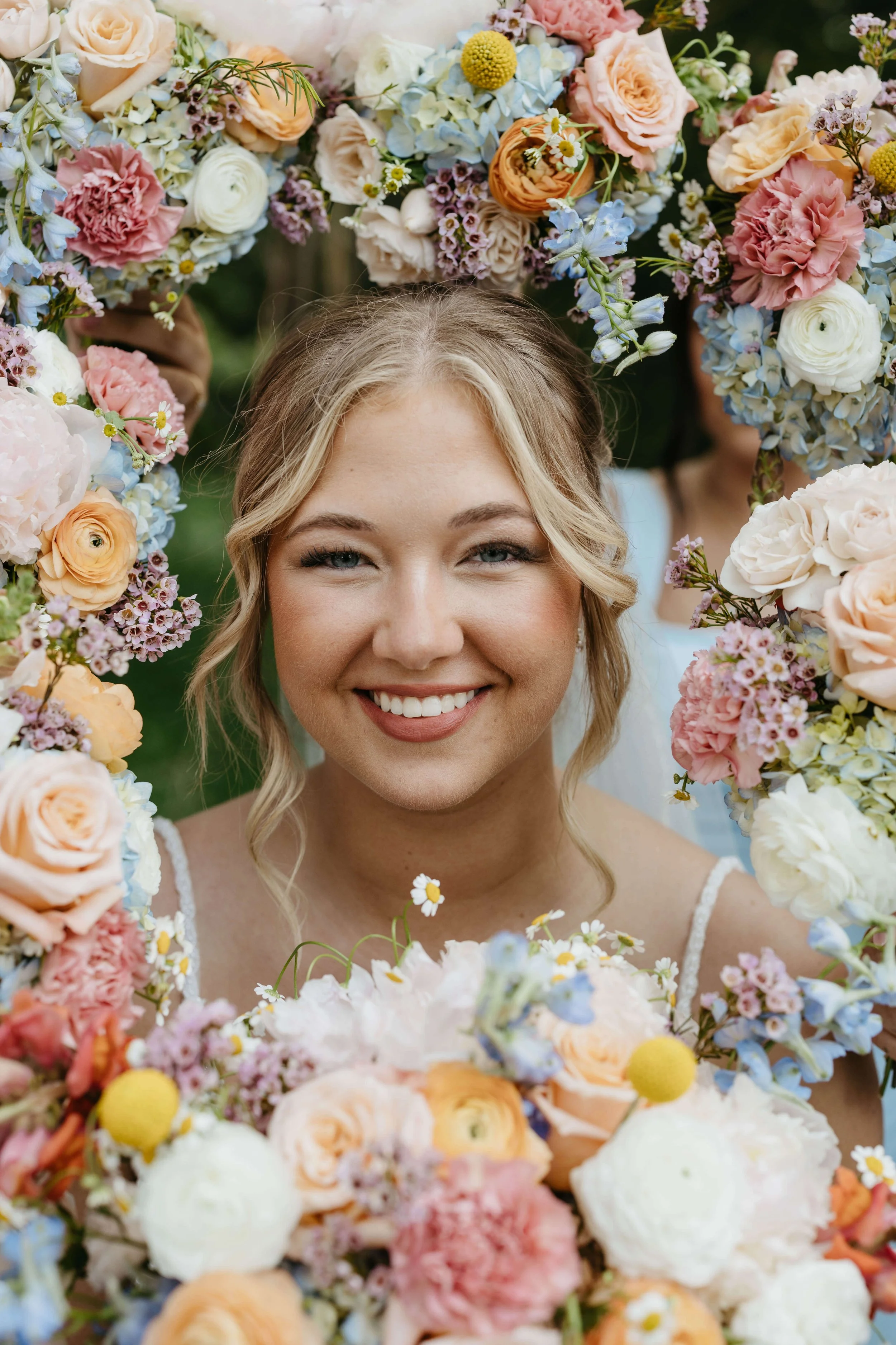 Stunning portrait of bride on her wedding day surrounded by flowers of her bridesmaids in Sioux Falls, photographed by Jenna Heckel Photography.