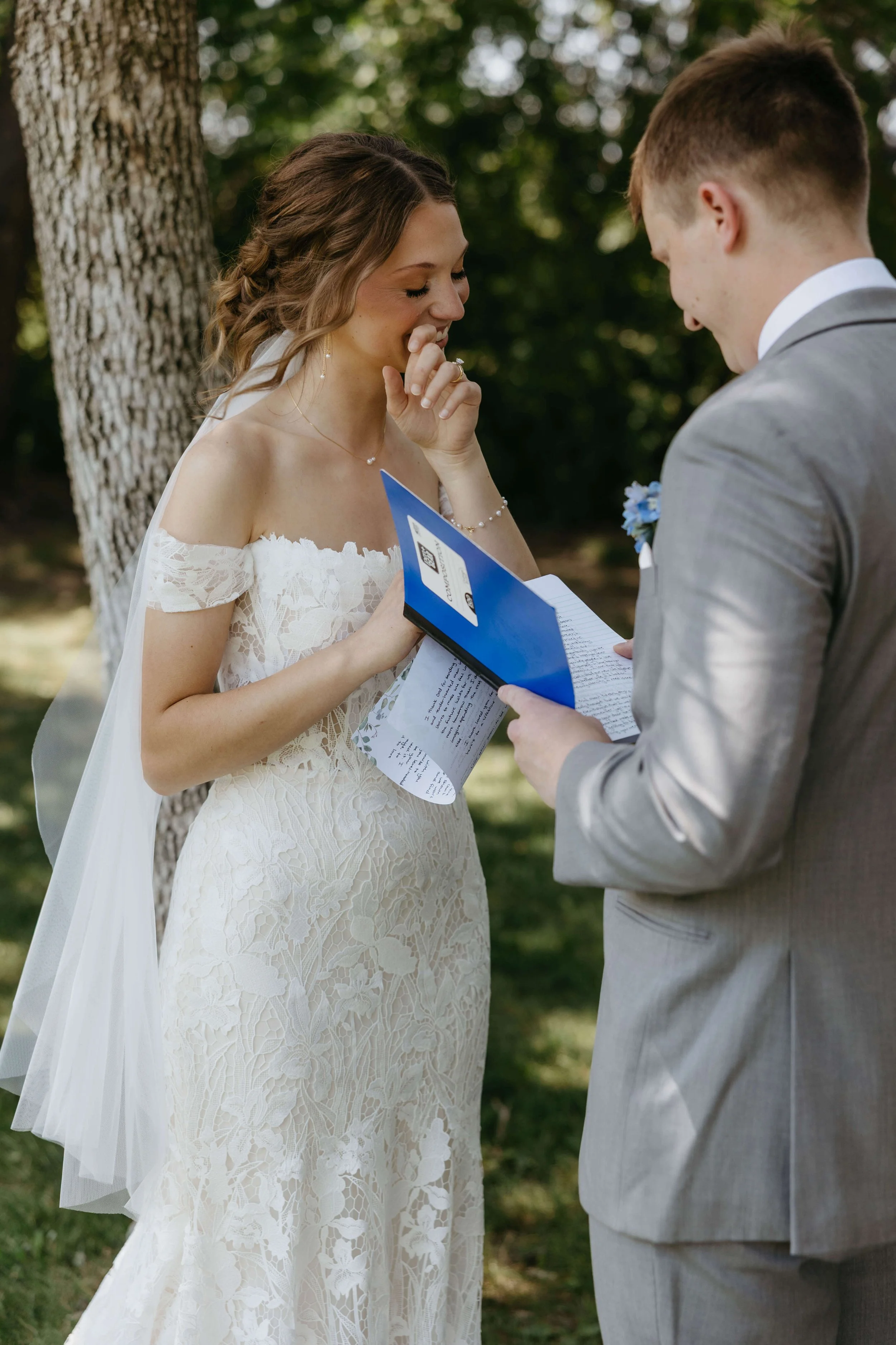 Bride and groom having an emotional moment reading private vows on their wedding day at their wedding venue The Meadow Barn in Harrisburg.