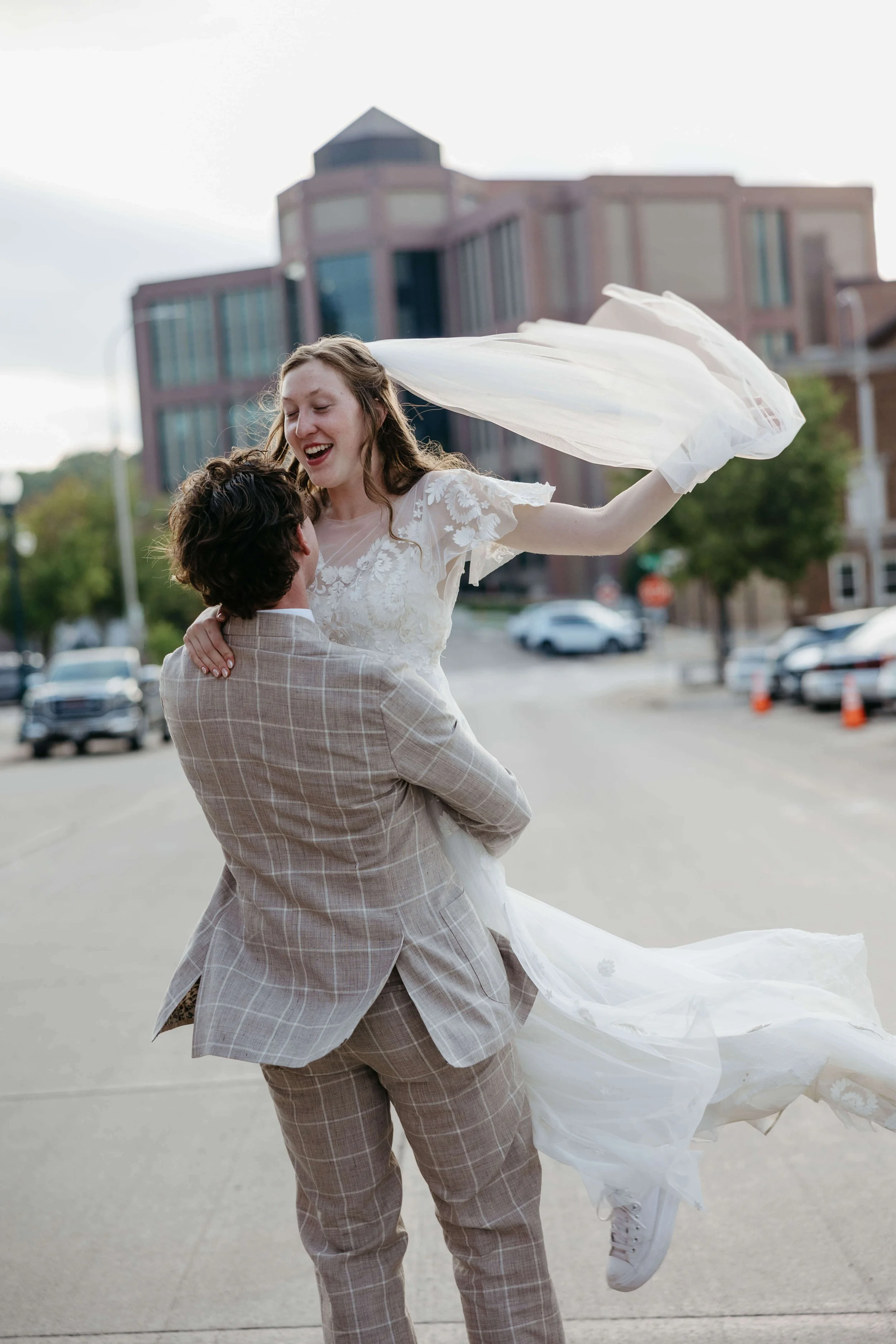 Couple smiling at each other during sunset portraits at Mosaic wedding venue in downtown Sioux Falls photographed by Jenna Heckel Photography. 