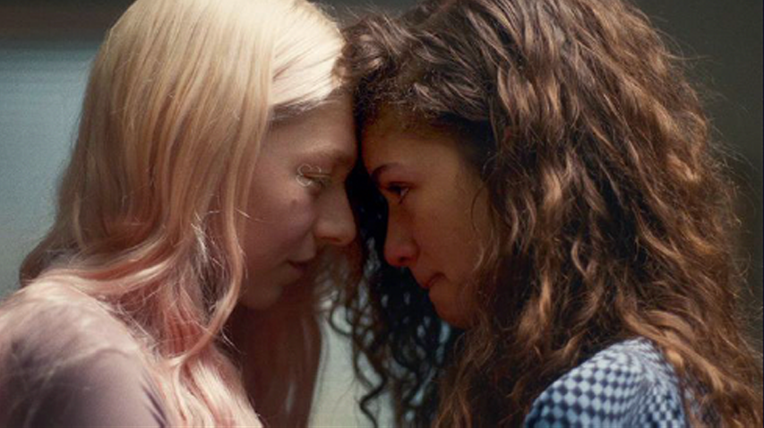 Two women with foreheads touching, eyes closed, showing emotional connection, in close-up shot.