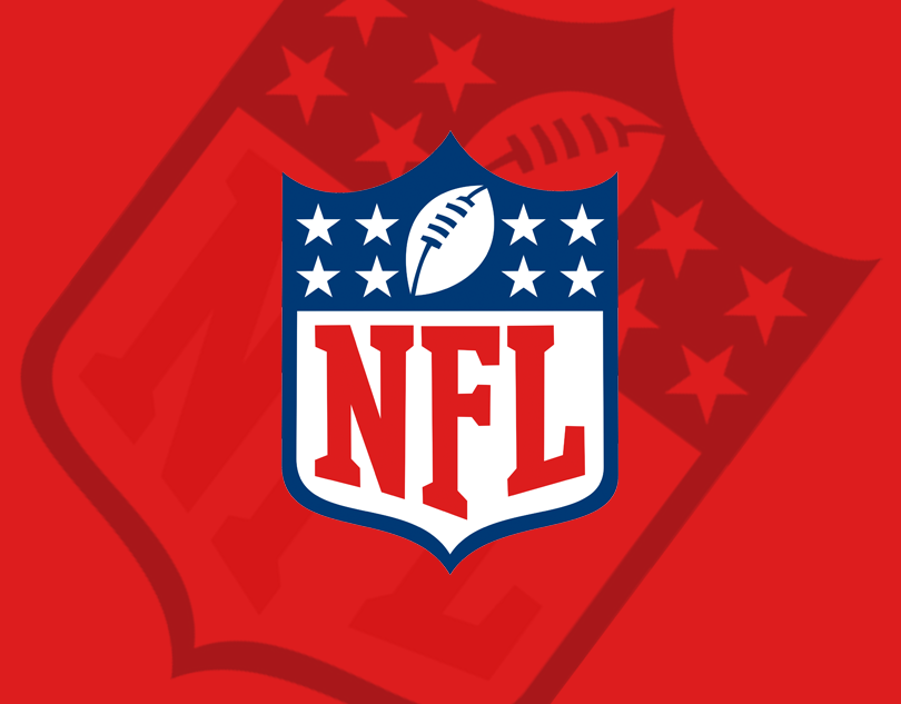 NFL logo featuring a shield with a football and stars on a red background with an enlarged NFL shield in the background.