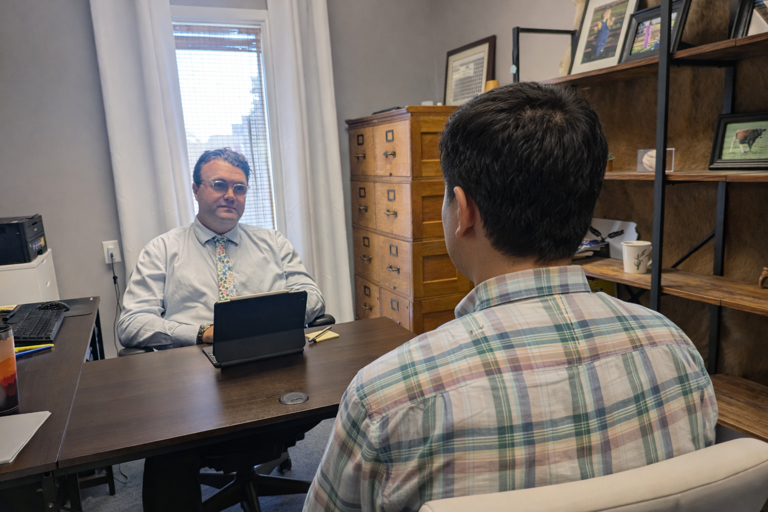 Small business law attorney in Kansas reviewing contract with client.