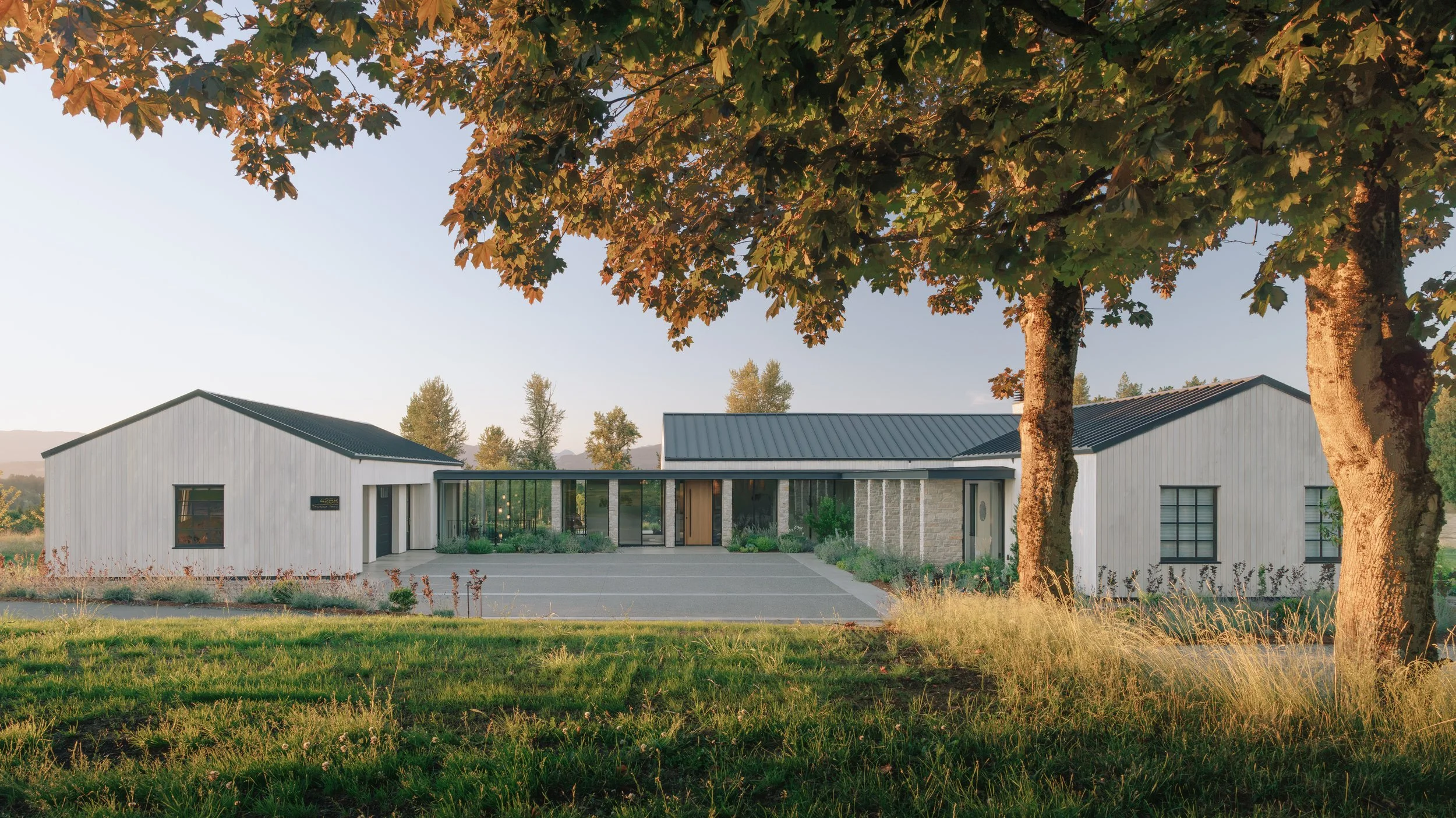 A modern architectural house with three wings labeled 'Utilize,' 'Gather,' and 'Rest,' connected by glass corridors, featuring a central courtyard with greenery.