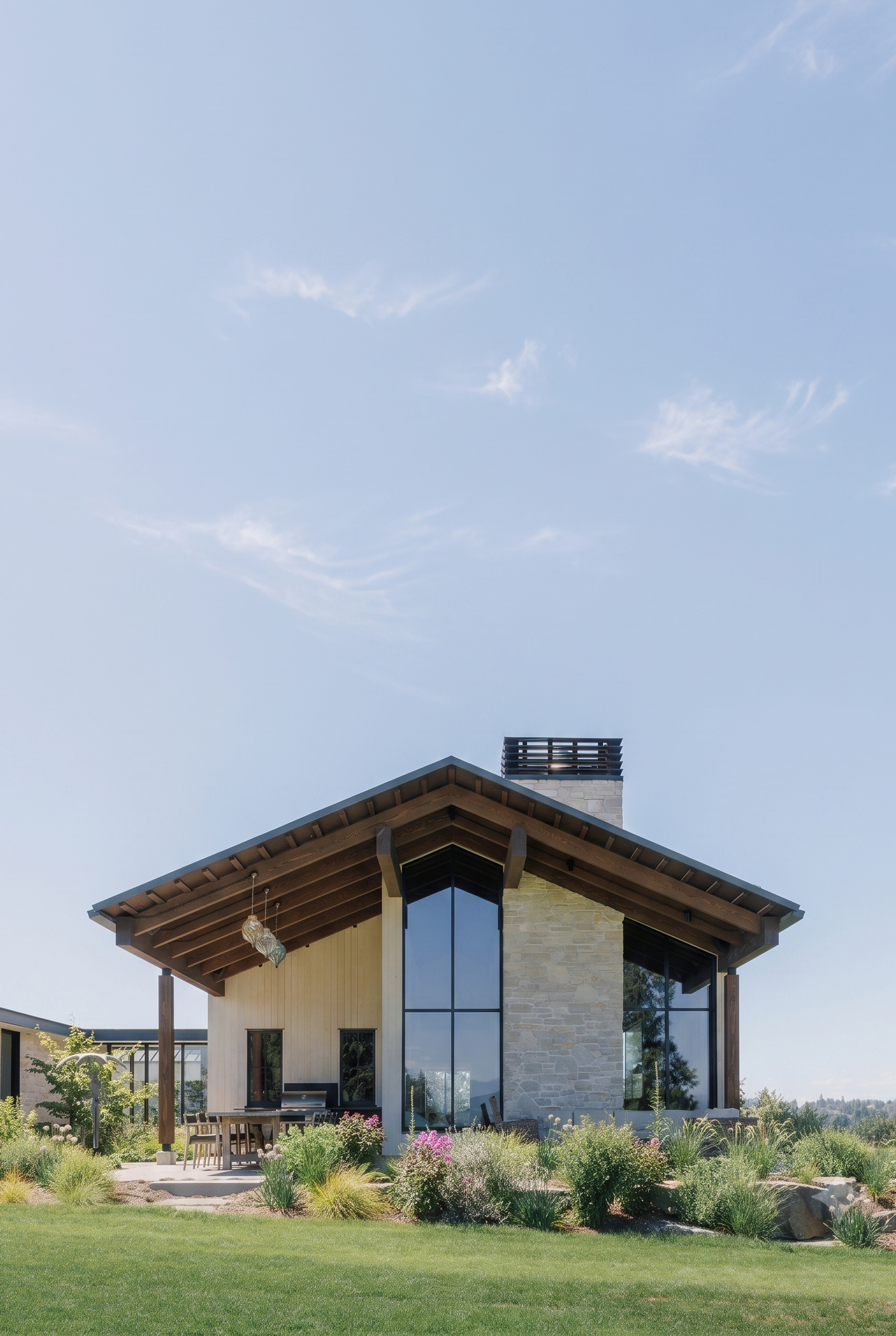 Single-story contemporary home surrounded by landscaping, made of natural materials like stone and wood, featuring a gable roof and a swimming pool in the front yard.