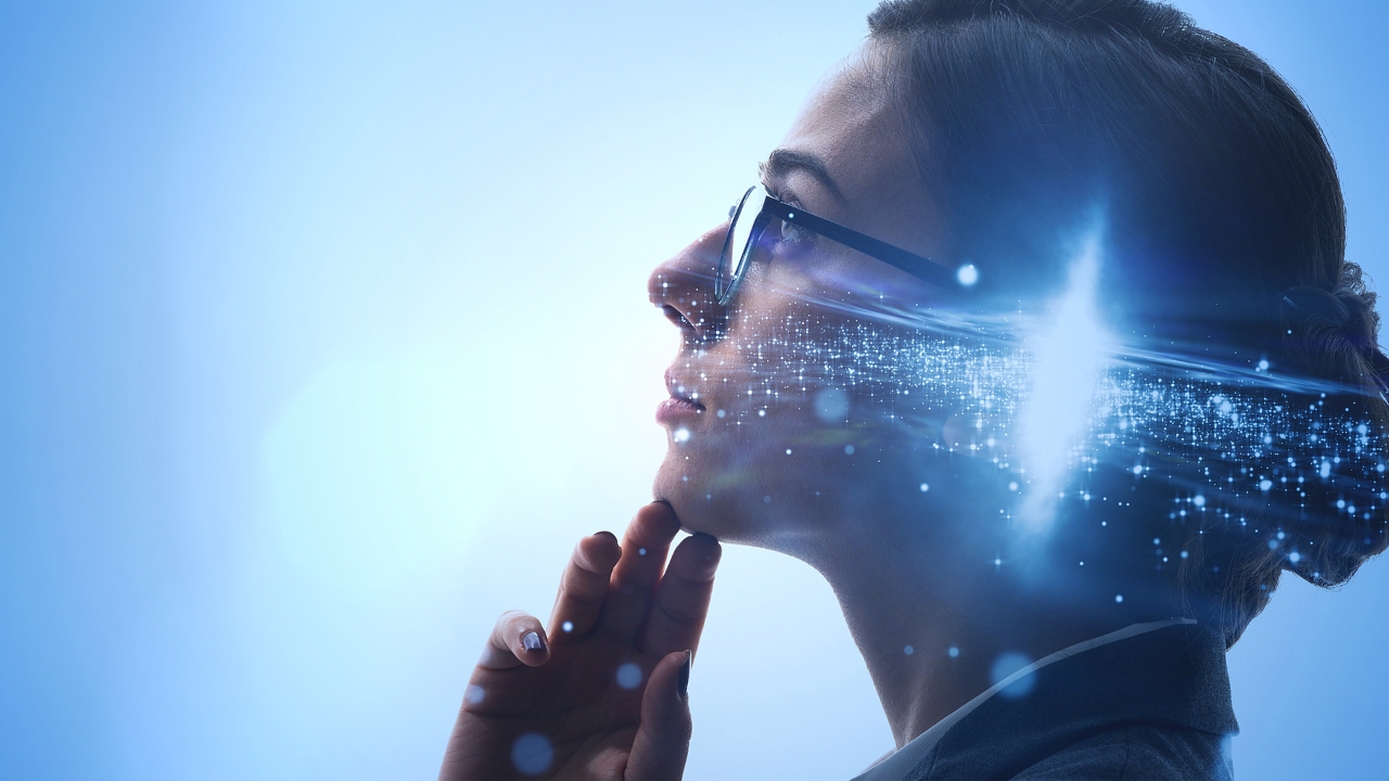 A woman with glasses touching her chin, with digital light effects and a futuristic, technological overlay on her face.