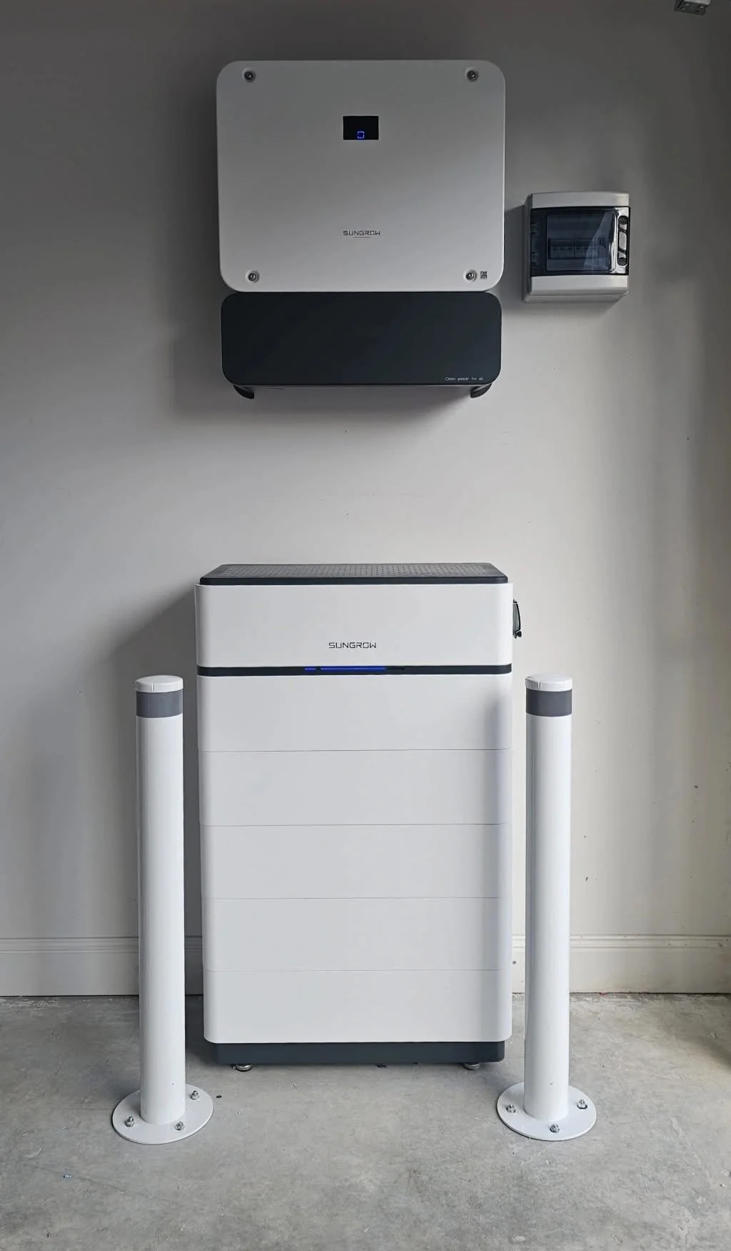 Solar power inverter system with two stacked units, mounted on a wall, with a small control panel to the right and a Weather station below.