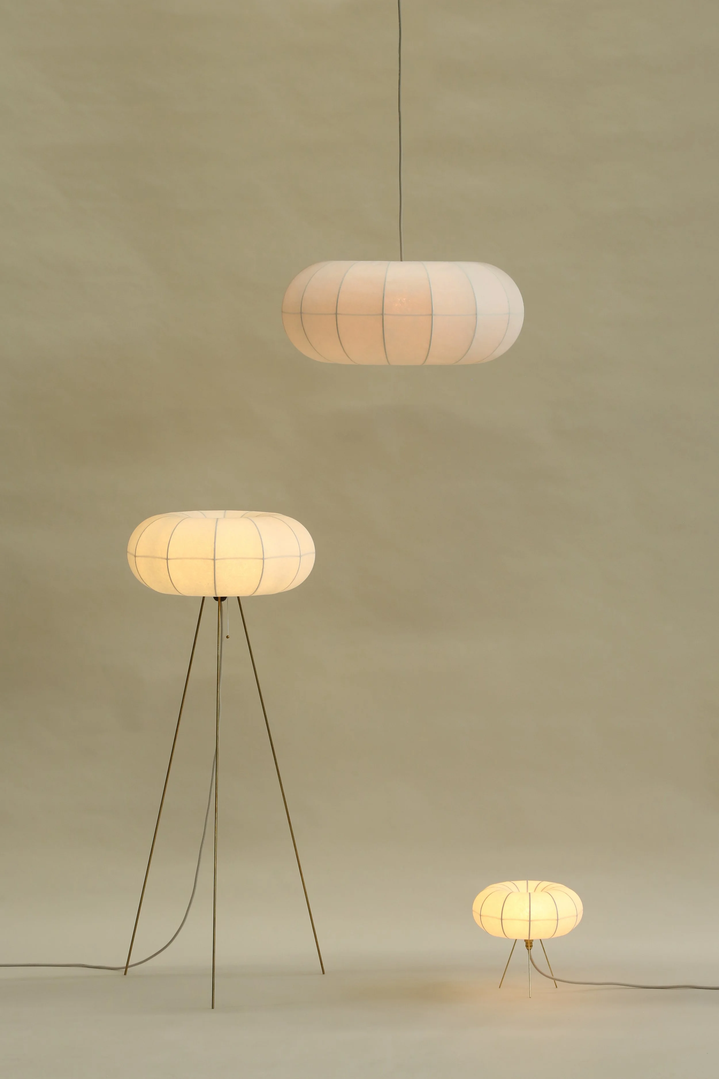 Plumus Lighting Collection by Claud Christian featuring sculptural paper pendant, floor, and table lamps with flowing curves for contemporary interiors.