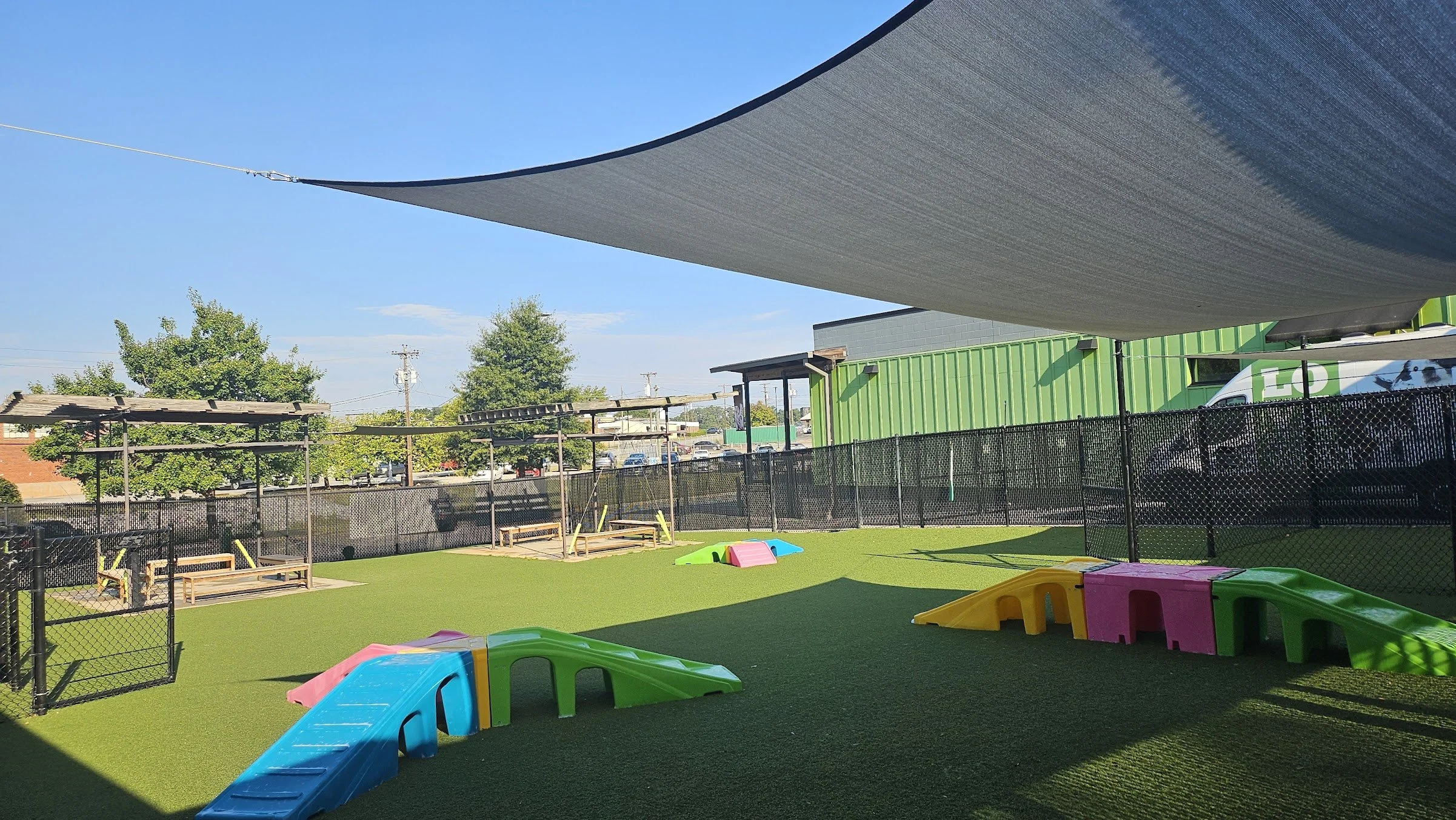 A large, covered play yard featuring colorful ramps situated throughout.