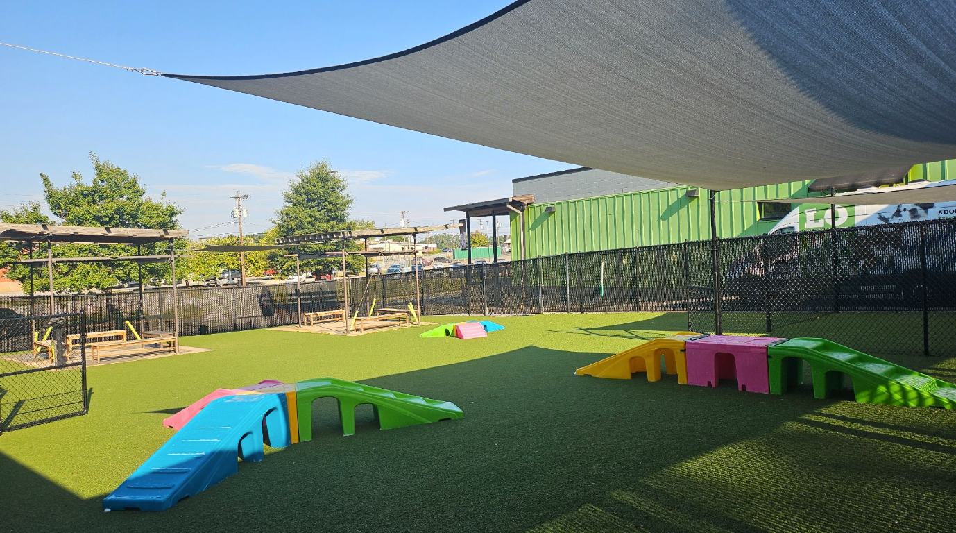 A fenced-in playgroup area with colorful ramps.