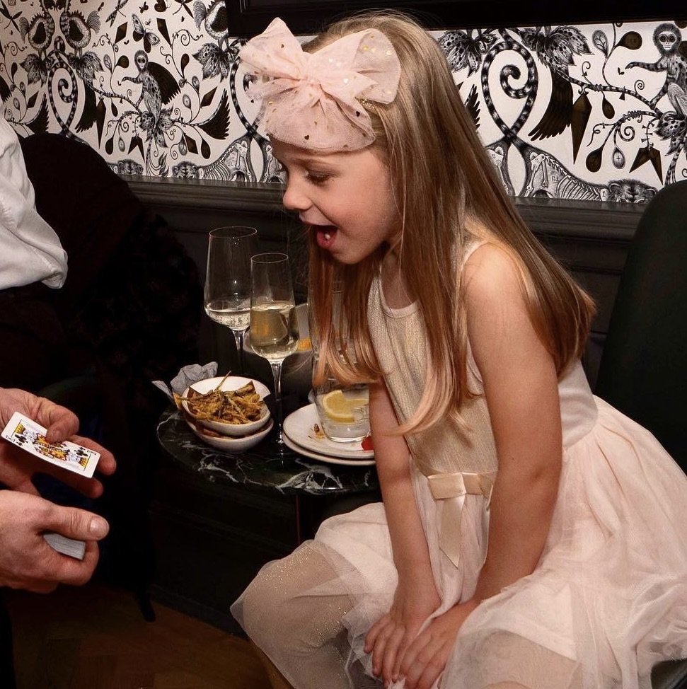 Close-up magician with girl at party.