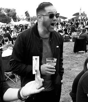 Card magician performing at street party.