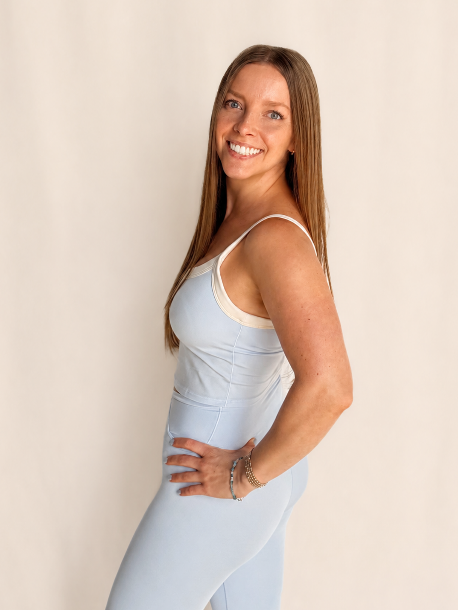 Woman in a light blue two piece smiling at the camera. 
