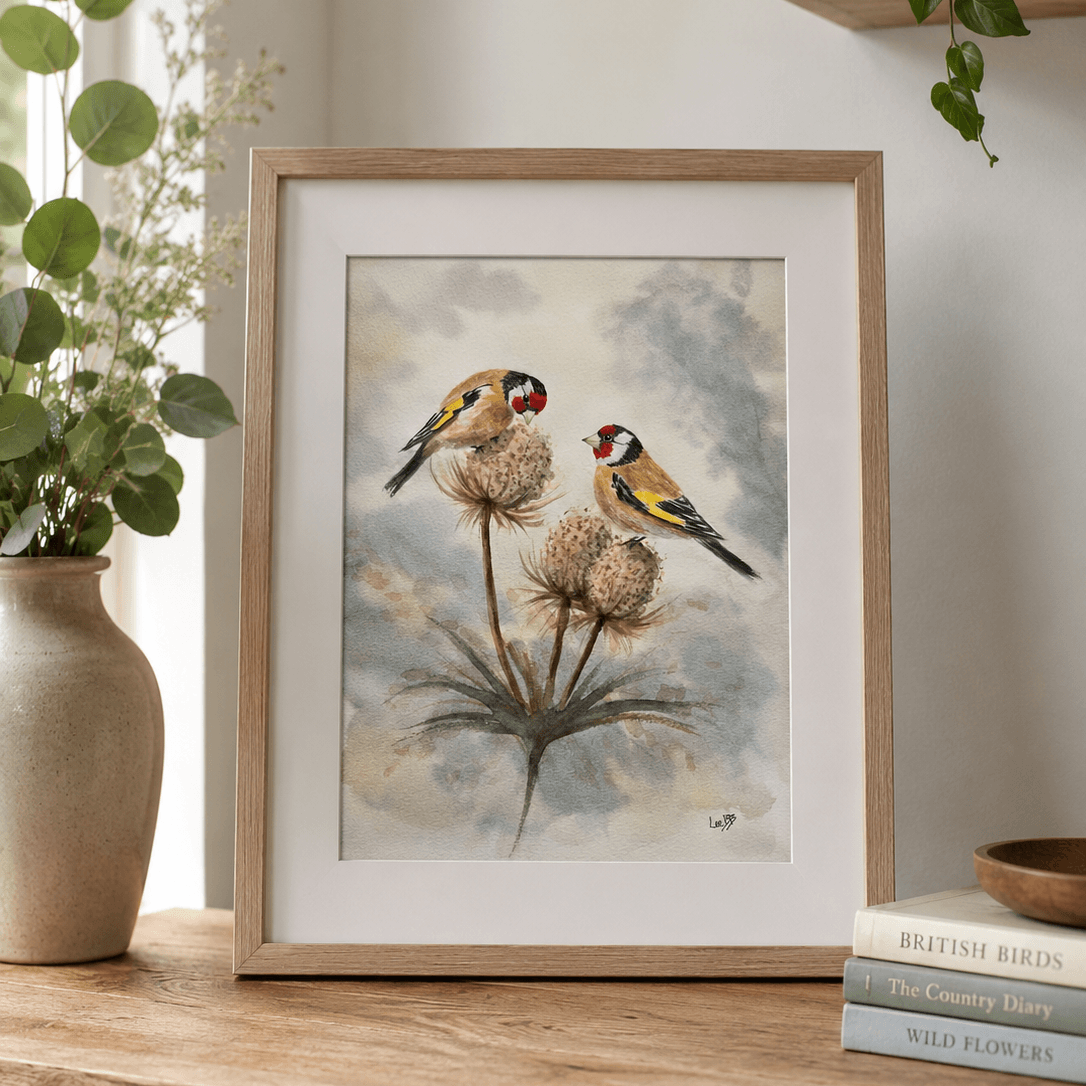 Watercolor painting of two goldfinches perched on thistle seed heads, with a cloudy sky background.