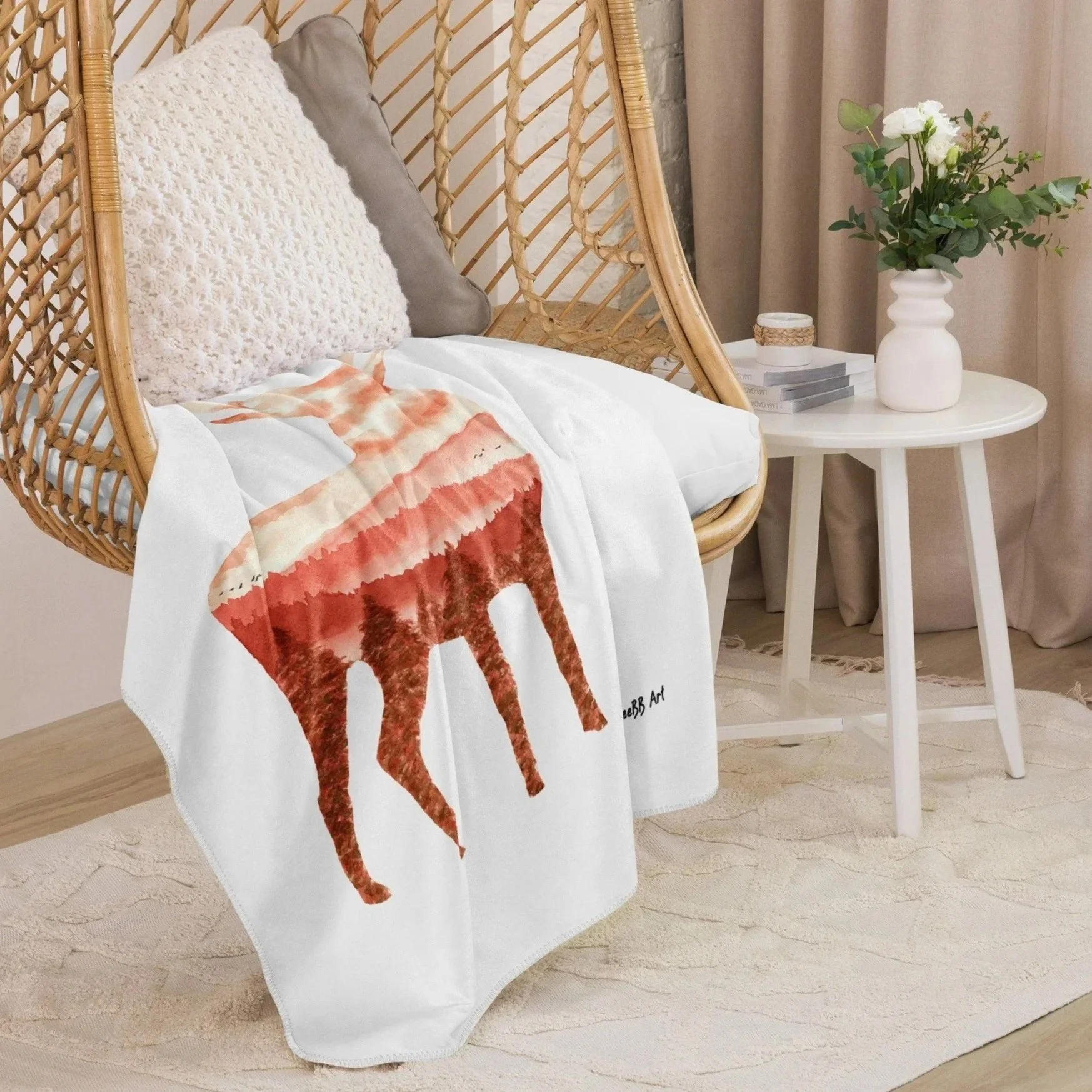Wilderness Stag Sherpa blanket draped over a wicker chair in a cosy interior