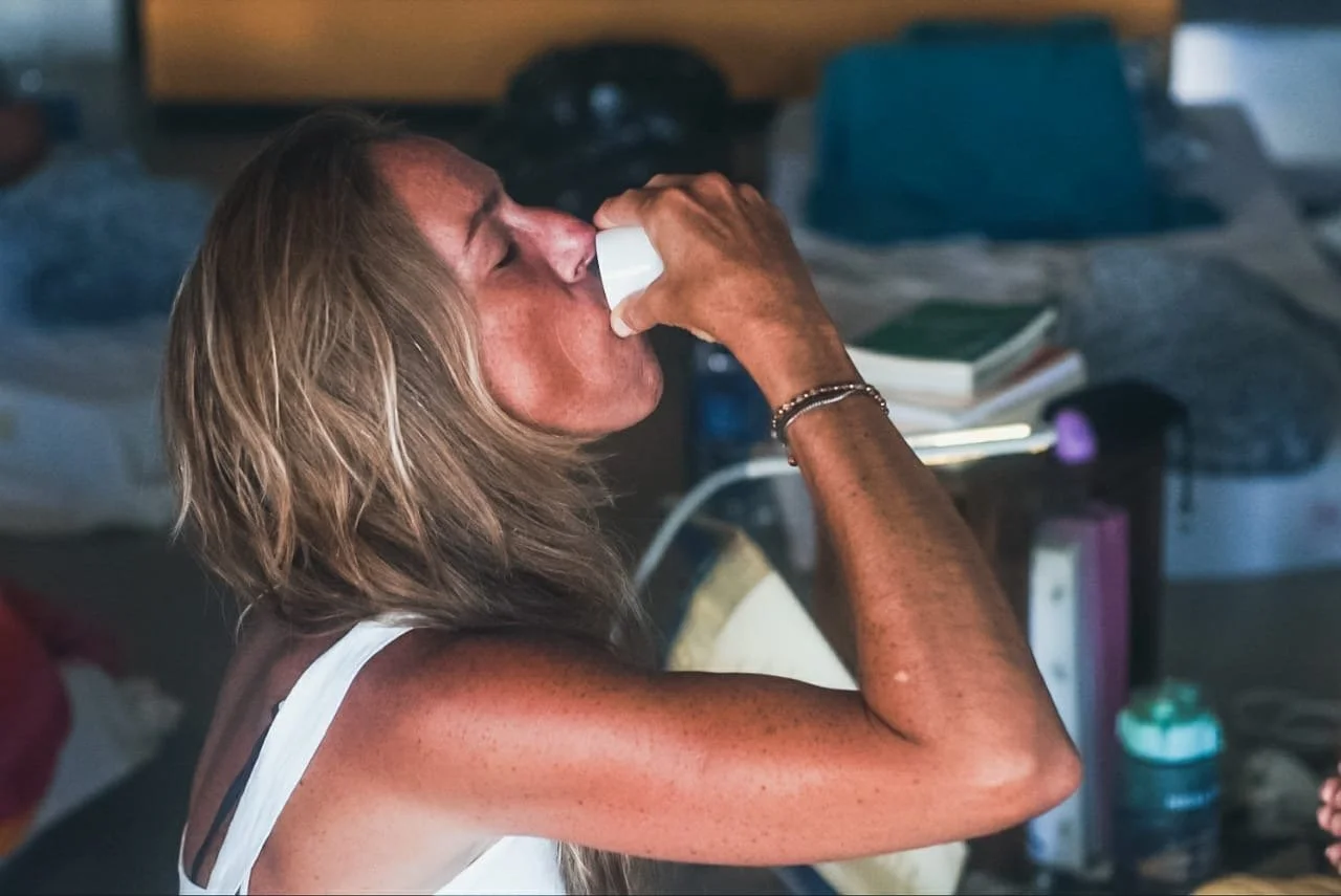 Mulher bebendo ayahuasca durante uma cerimônia de plantas indígenas no Retiro Maravilha em Búzios, Brasil, próximo ao Rio de Janeiro, Brasil