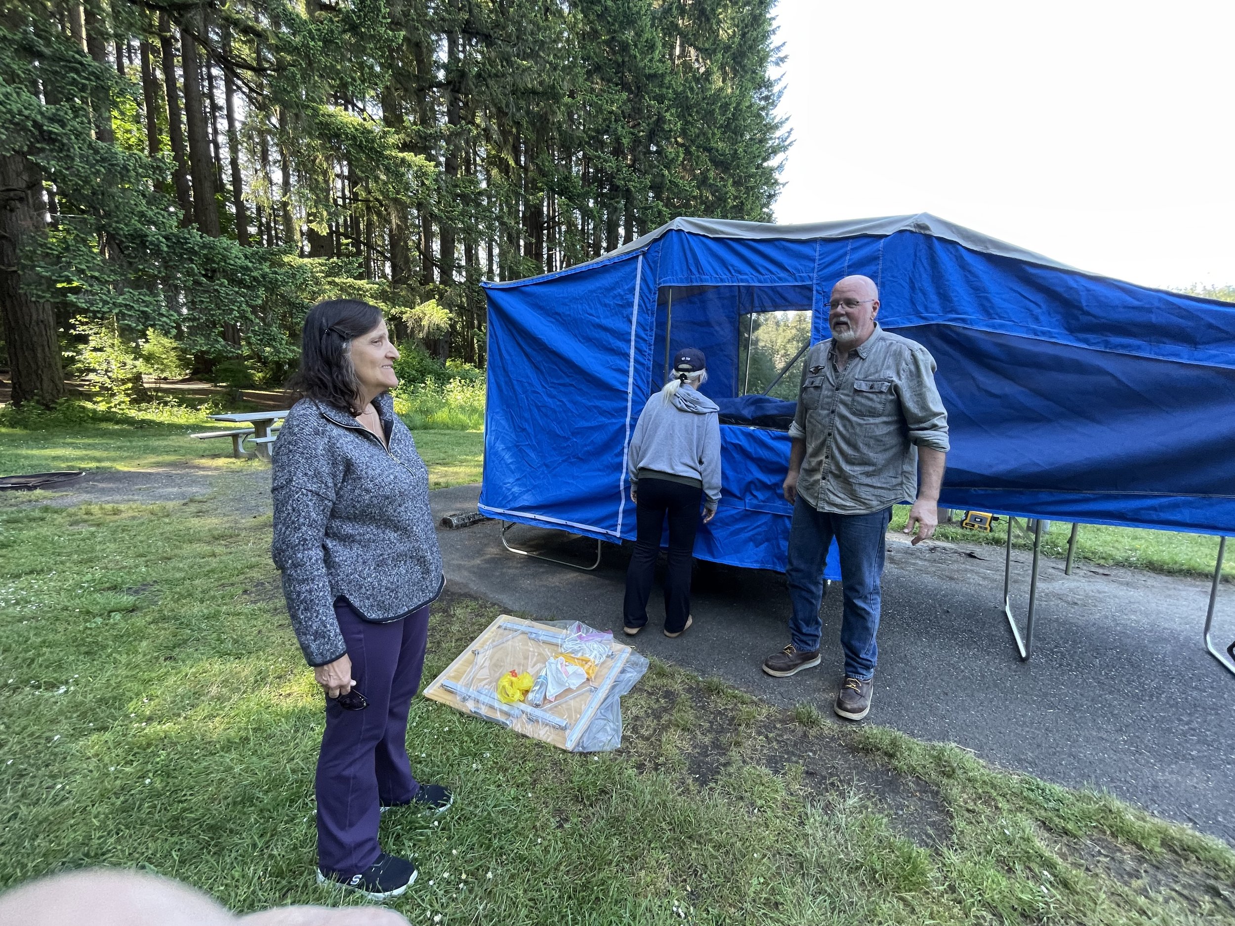Dave the Buddha Biker talking with a group of women  campers at Millersylvania State Park Washington who  stopped to ask questions about the Time Out Deluxe  motorcycle camper trailer