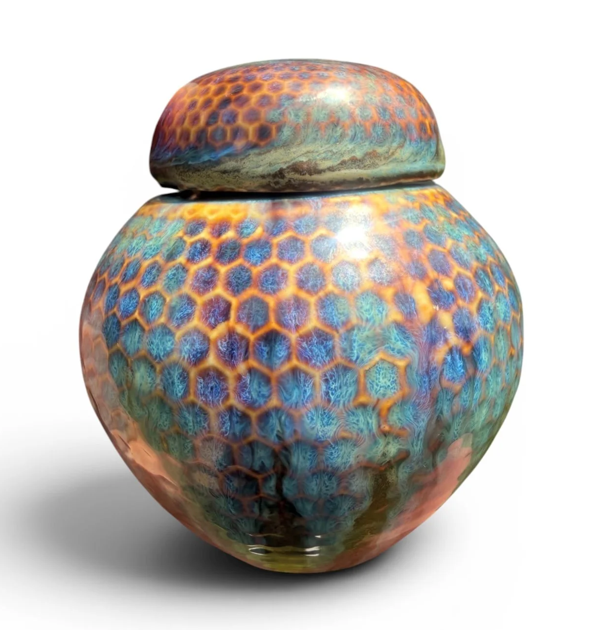A decorative ceramic urn with a hexagonal pattern and vibrant, colorful designs made by Tara Hinkley from Creative Lotus Shop