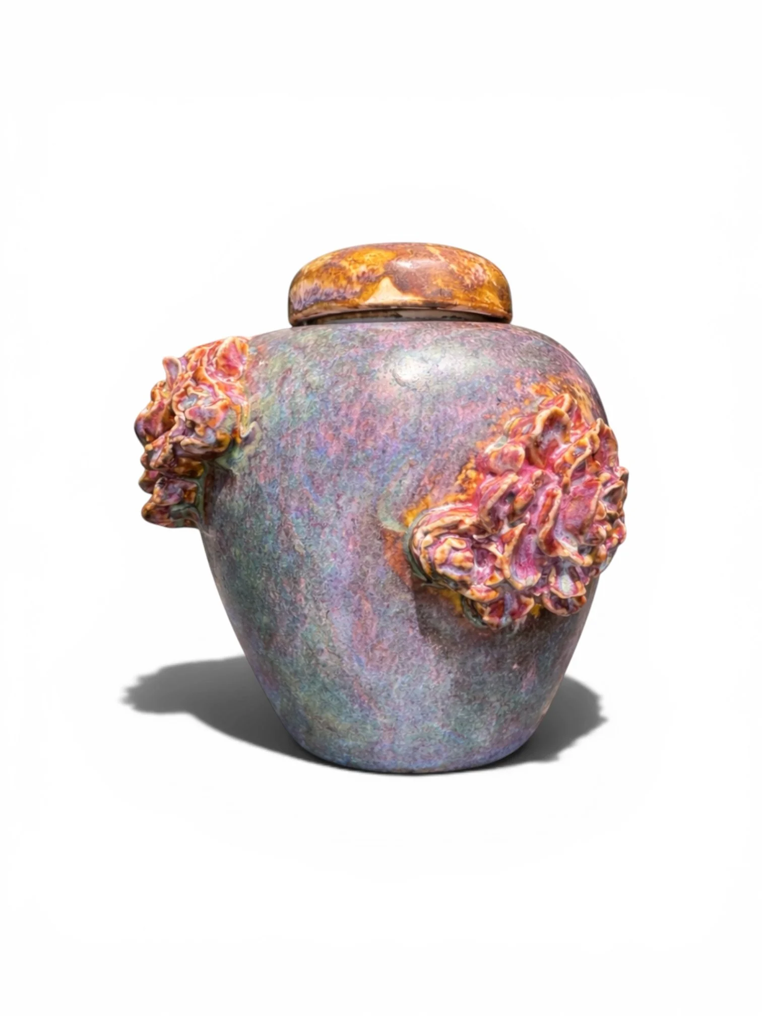 Colorful ceramic vase with ruffled handles, casting a shadow on a white background.